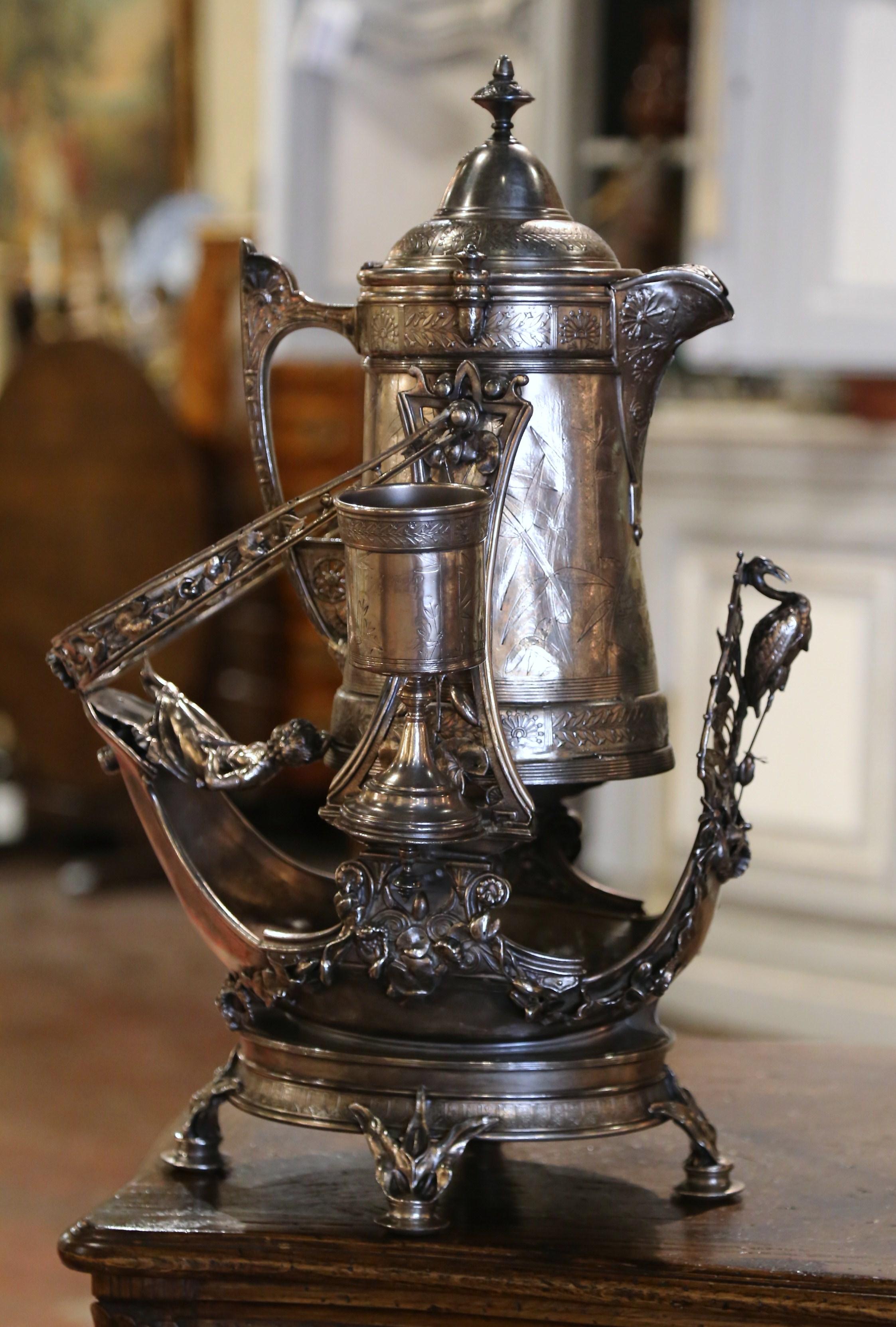 Decorate your bar, cellar or cabinet with this decorative silvered copper samovar. Crafted in England by Reed and Barton circa 1905, the tea drinking device stands on a tilt stand; the container is accompanied by two exquisite goblets. Ideal for