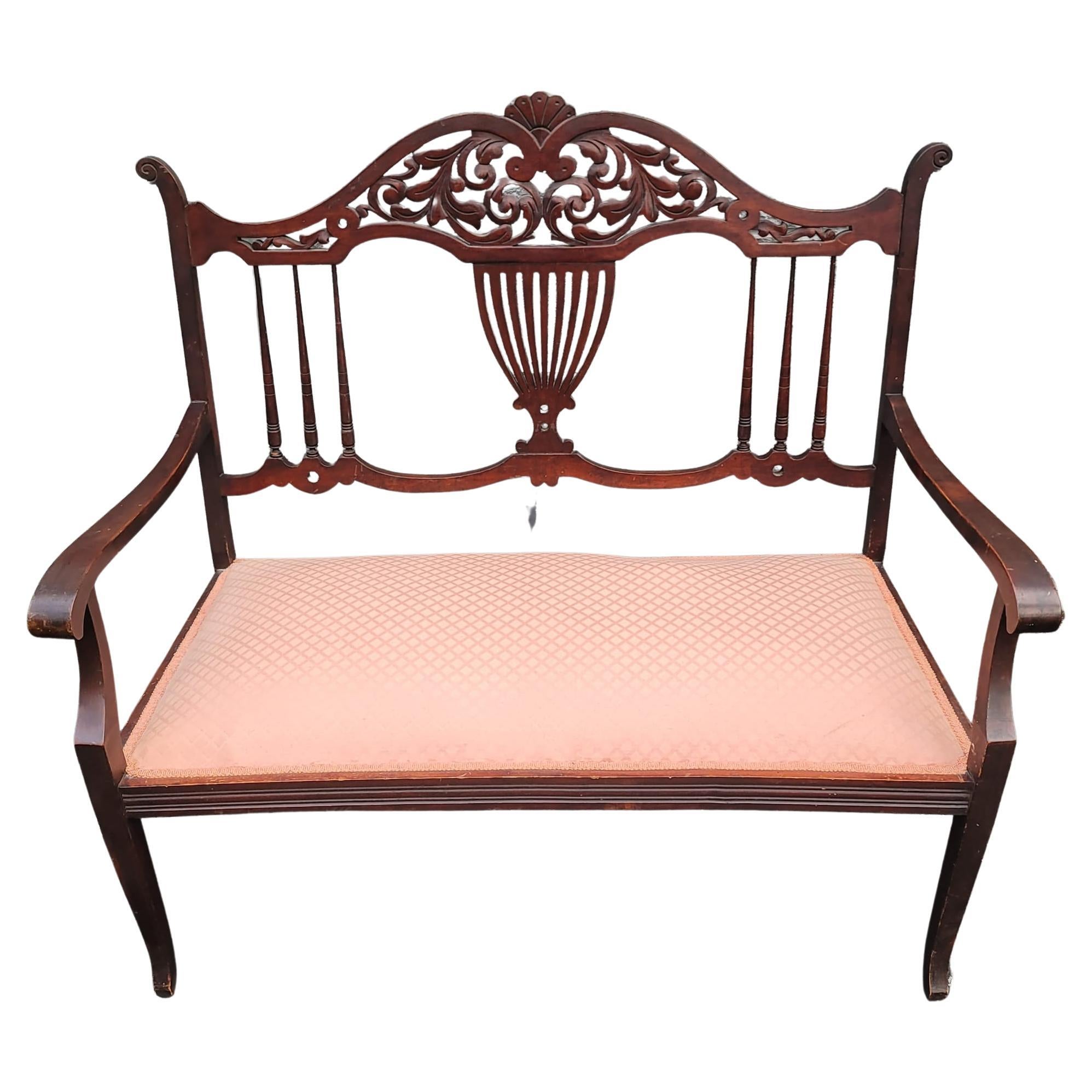 Early 20th Century Regency Carved mahogany and Upholstered settee. It measures 40.75