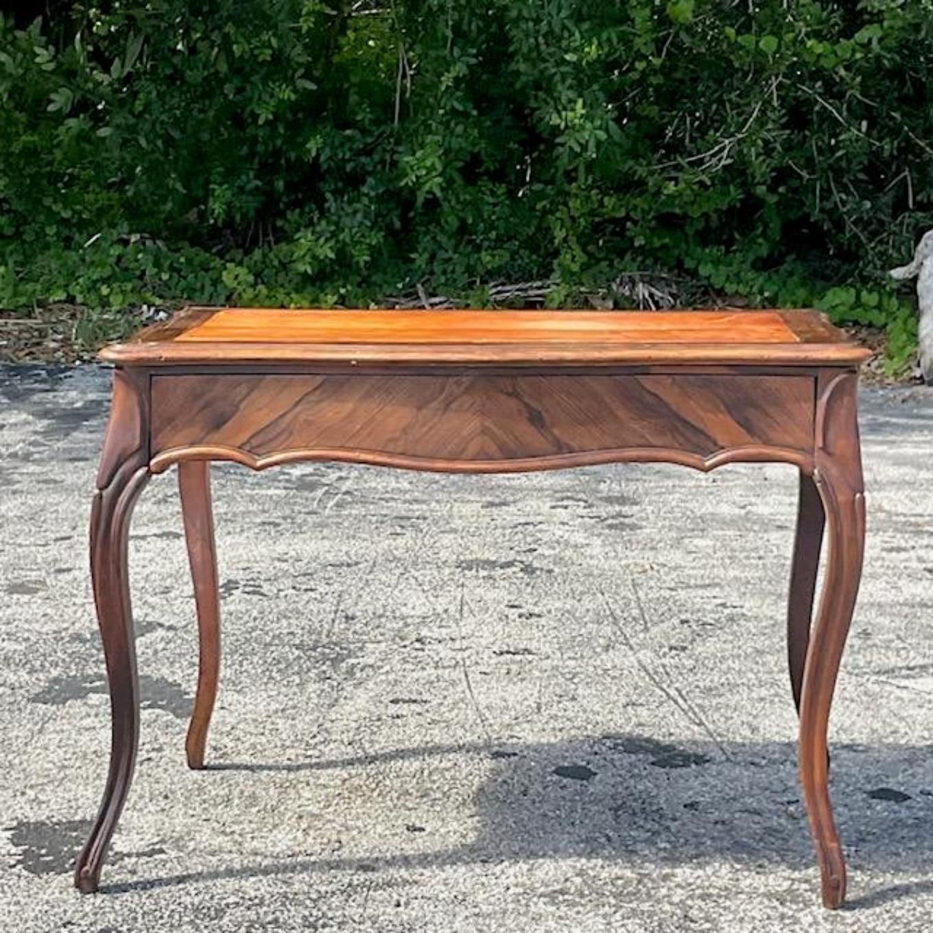 A fabulous vintage Regency writing desk. Beautiful Burl wood frame with carved cabriolet legs. Inset embossed leather top. Acquired from a Palm Beach estate.