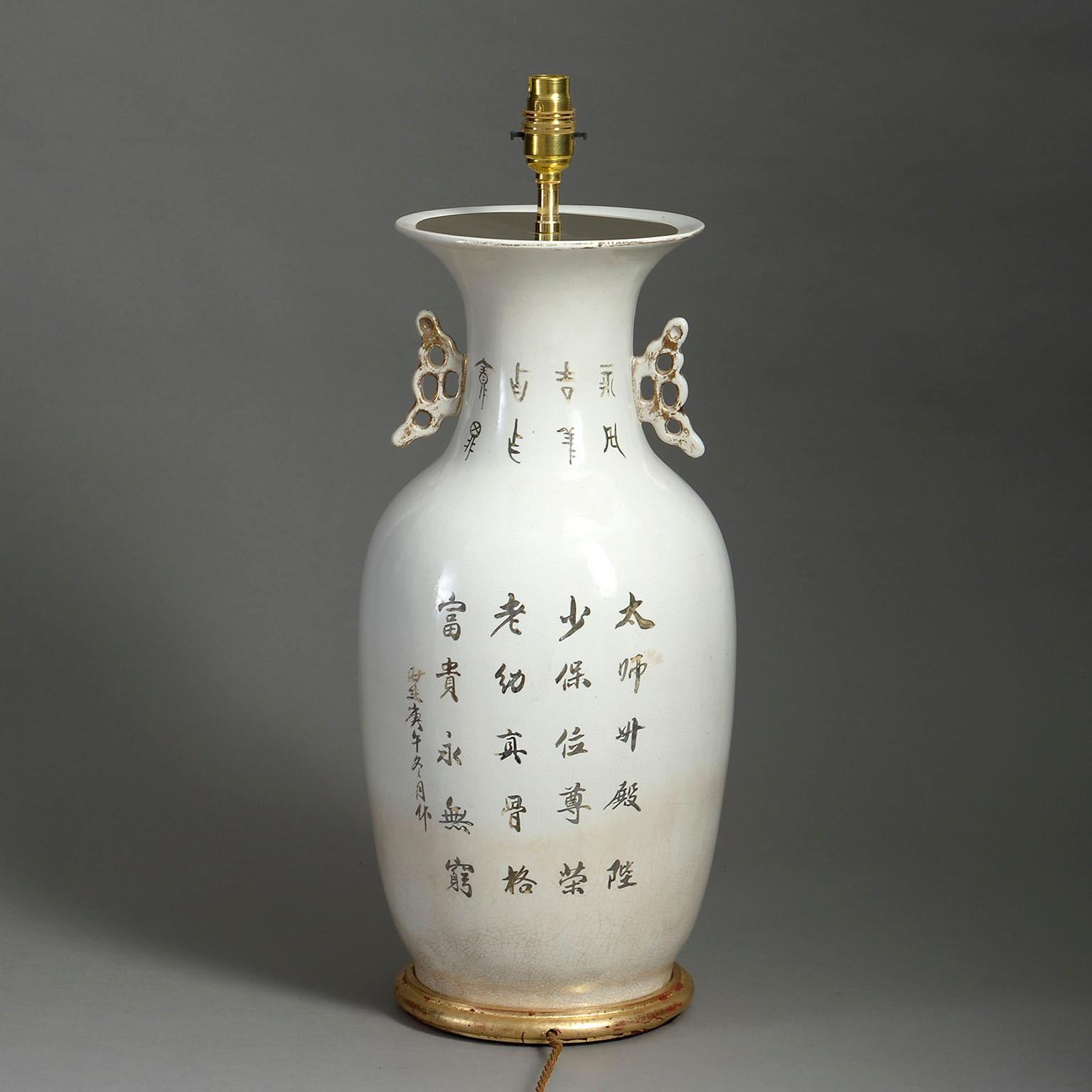 An early twentieth century Republic Period porcelain vase, decorated with a foo-dog in red glazes upon a white ground, with Chinese characters verso. Now mounted as a lamp upon a turned giltwood base.

Dimensions refer to porcelain vase and