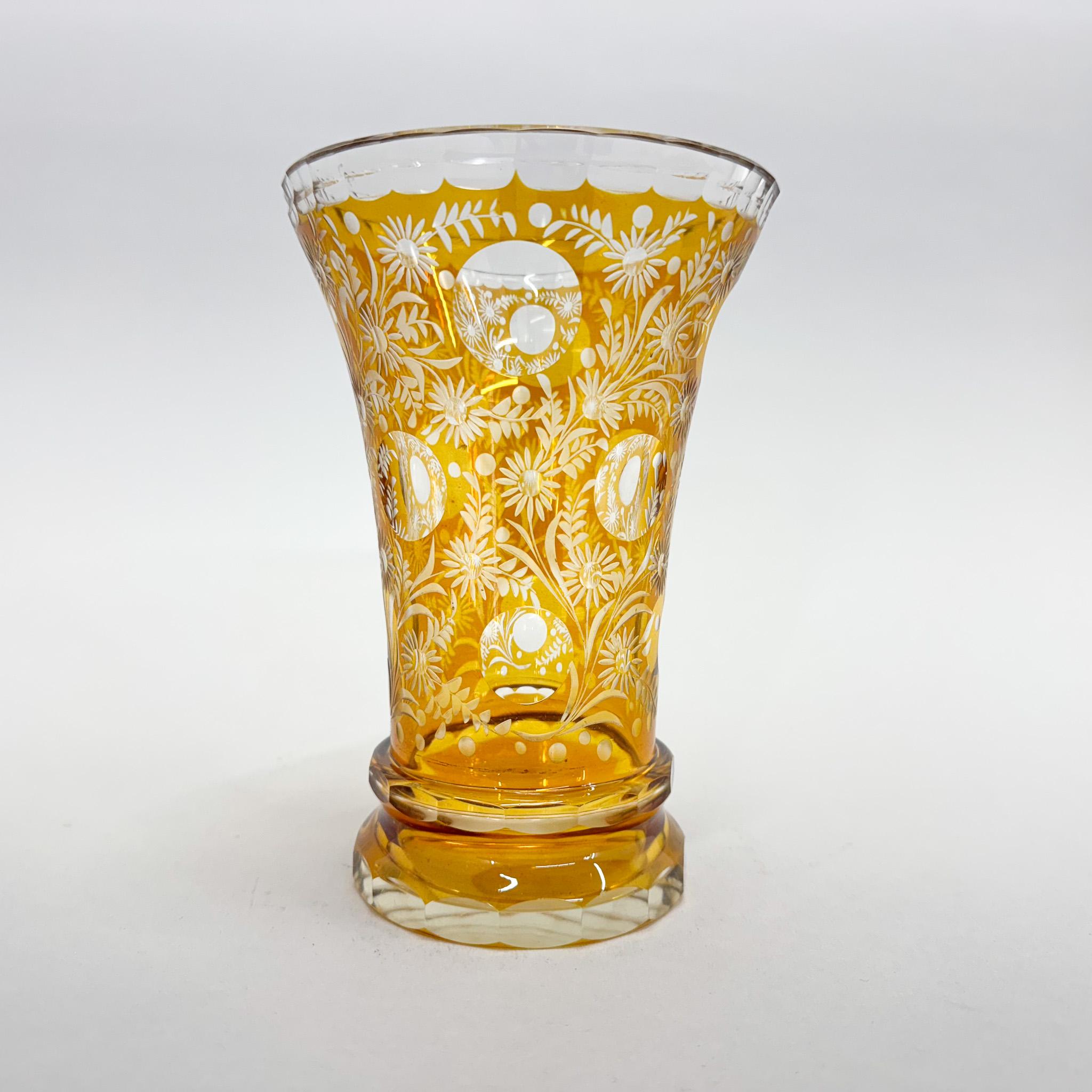 Verre transparent, recouvert d'une glaçure jaune. Le vase date du début du 20e siècle et est richement taillé à la main avec des motifs floraux. Il est doté d'une solide base ronde biseautée. Bon état vintage.