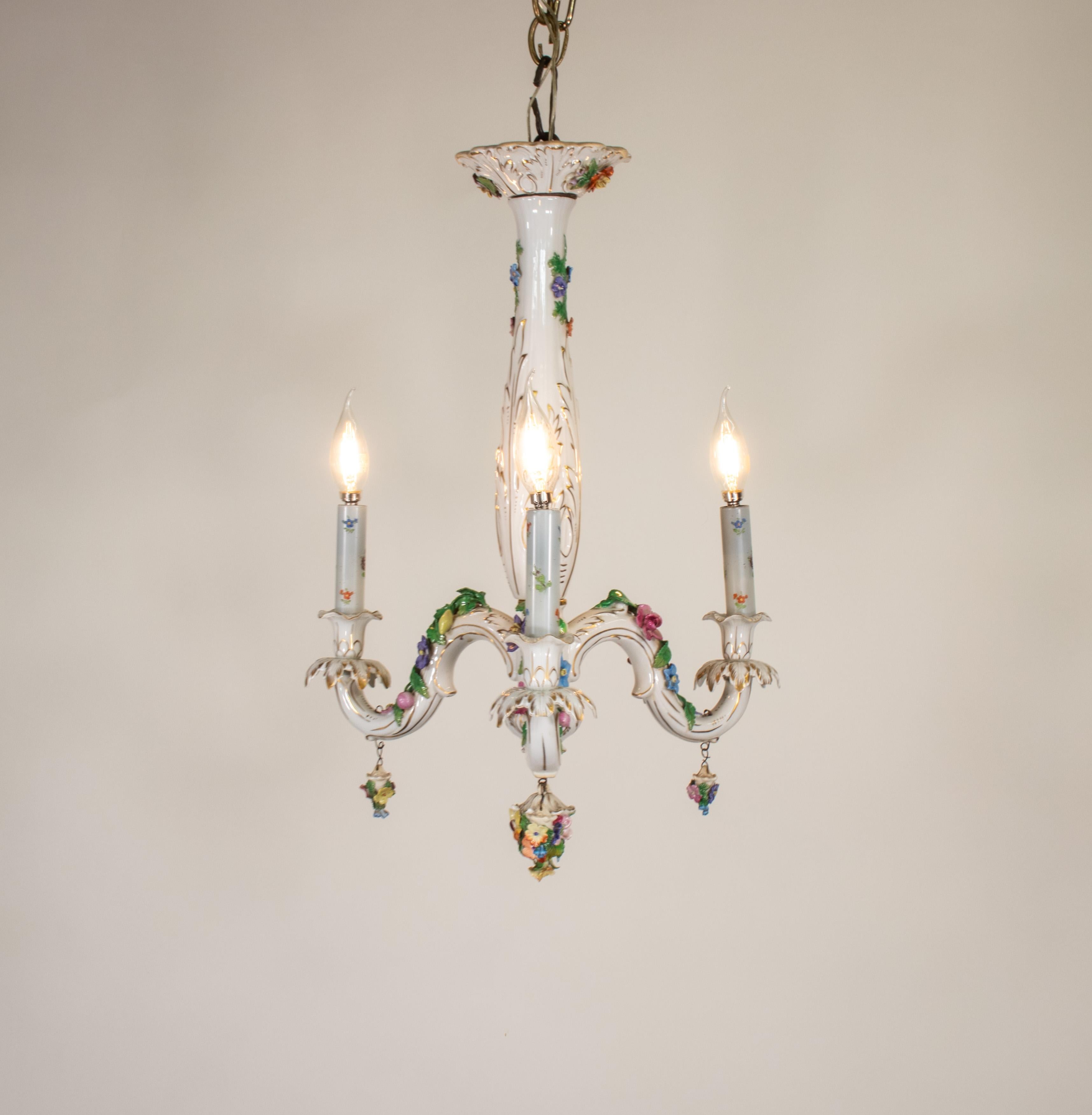 Questo piccolo e splendido lampadario in Dresden Porcelain ha tre bracci ondulati con pendenti bouquet floreali. Un'arte eccezionale, che esemplifica il revival dello stile rococò. Il corpo è realizzato in un'opulenta porcellana bianca dipinta a