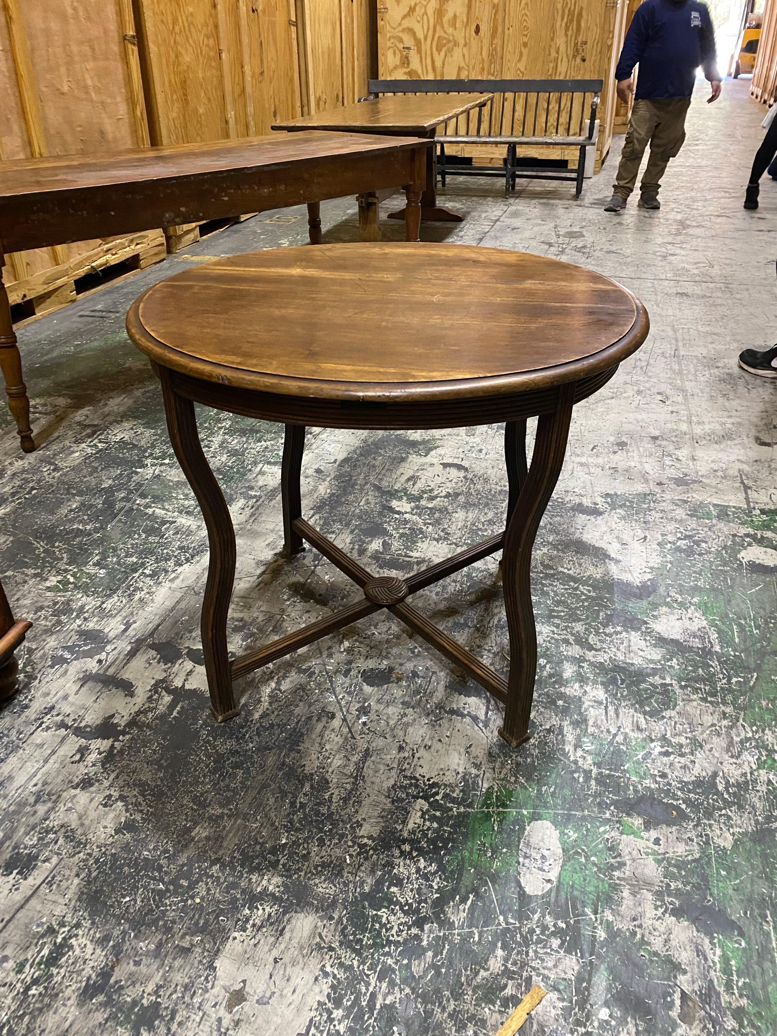 Table ronde en Oak du début du 20e siècle avec pieds en cabriole
Cette charmante table ronde ancienne en bois présente un design classique avec des pieds élégamment incurvés et une base en croisillons. La surface de la table porte le caractère de
