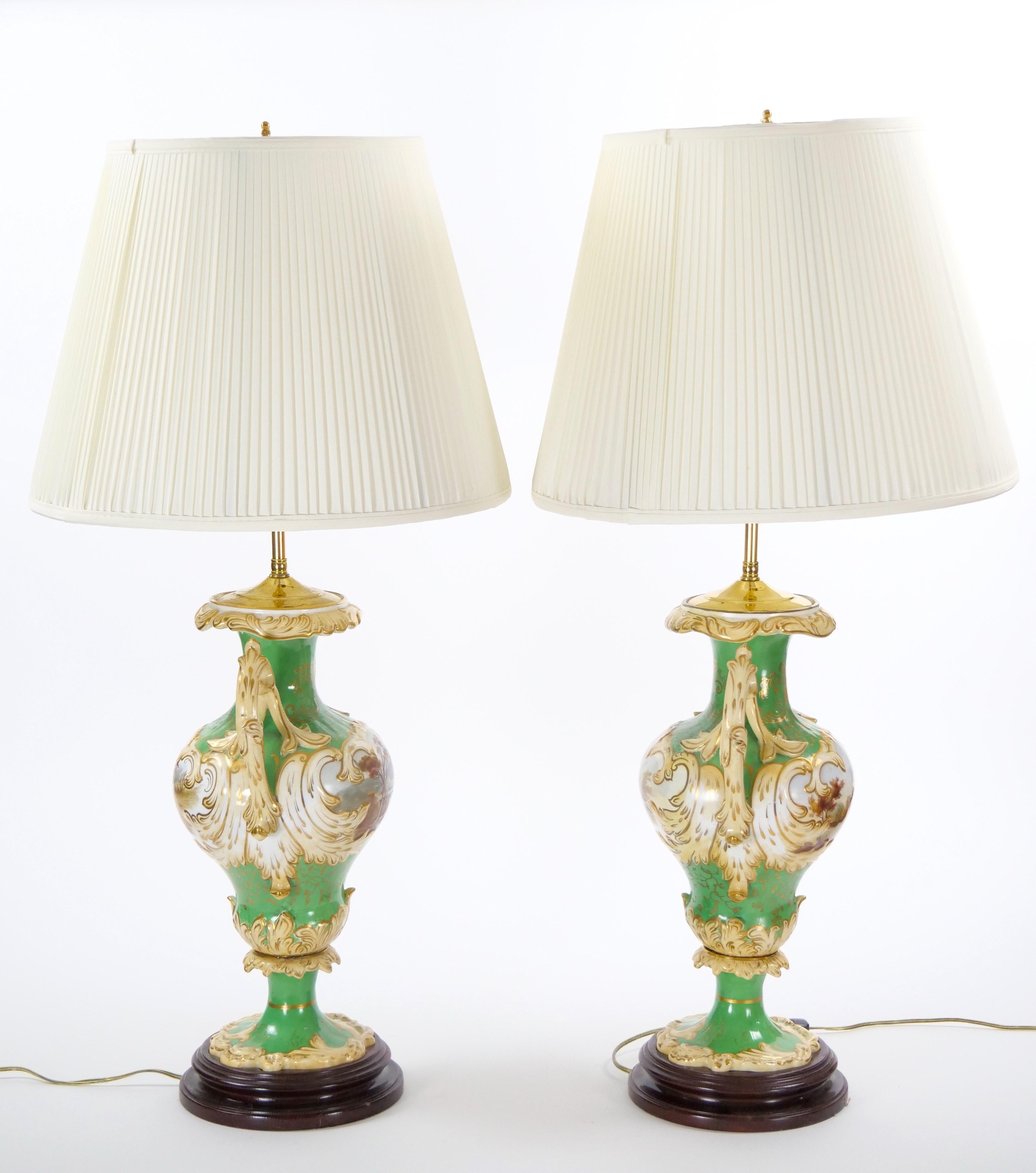 Cette exquise paire de lampes de table du début du XXe siècle de Royal Worcester témoigne d'un superbe savoir-faire et d'une grande qualité artistique dans le domaine de la porcelaine peinte et dorée à la main. Chaque lampe présente un élégant