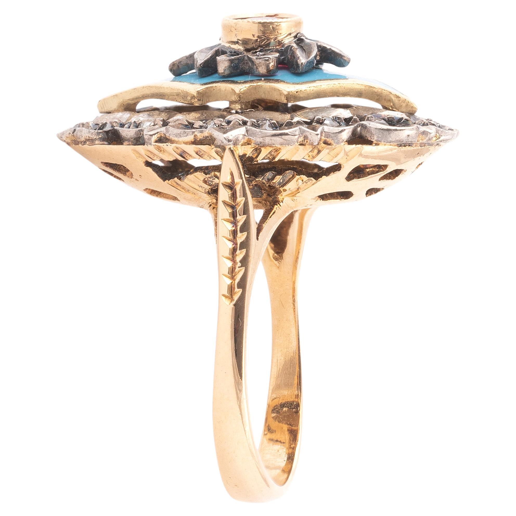 La bague avec un rubis rond, dans une bordure de diamants taillés en rose sur un émail céleste, montée en argent et en or.
Taille : 6 1/2
Poids : 8,26gr.
