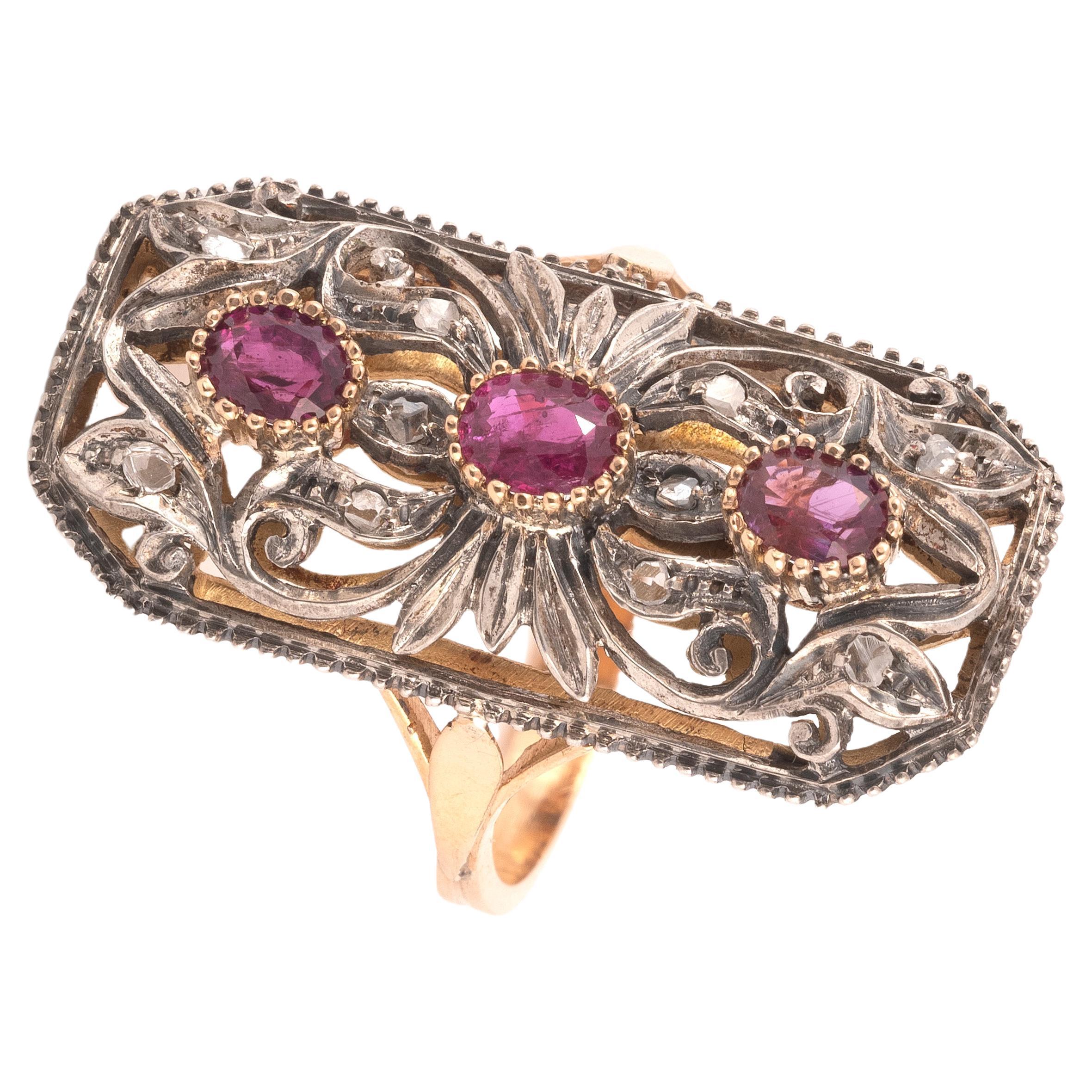 Les trois rubis ovales en formation verticale, dans une bordure de diamants taillés en rose, montés en argent et en or.
Taille : 8
Poids : 7.2gr.


