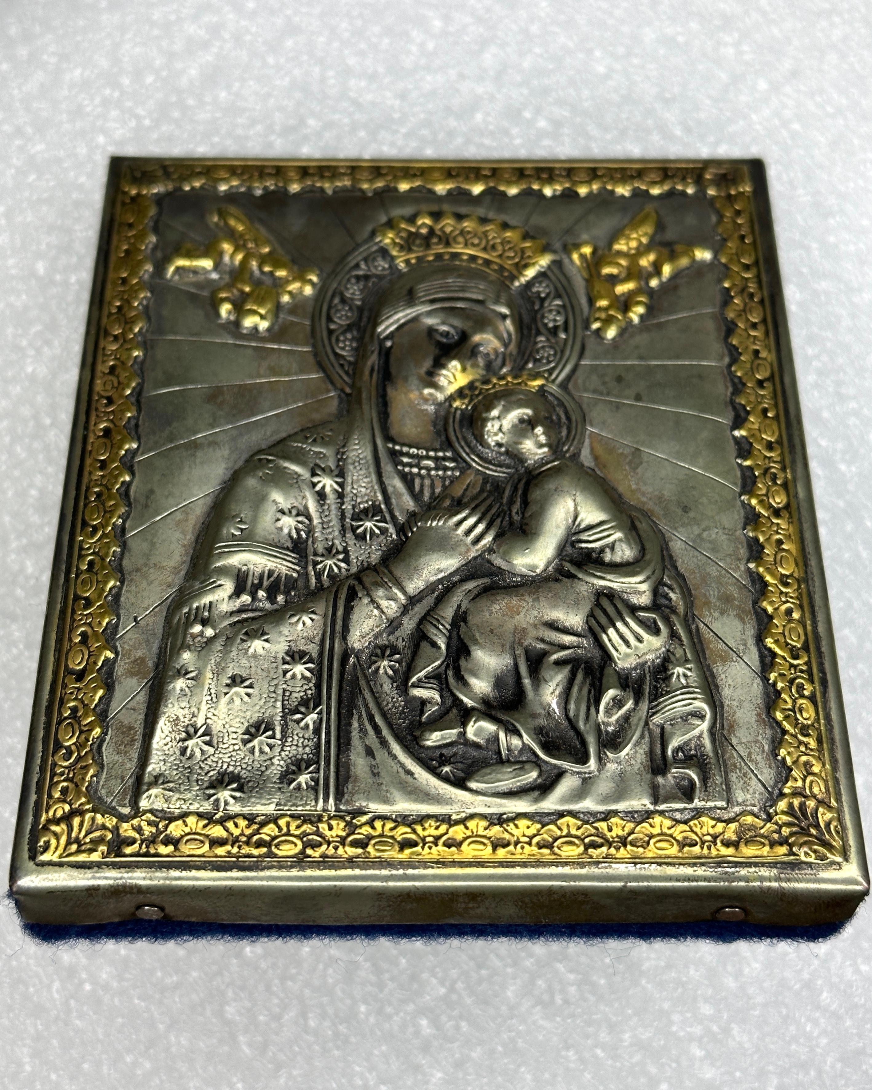 Russian icon of Madonna and Child from the early 20th Century.  The handmade icon features silvered sheet metal over wood with Repoussé work featuring etched, engraved, and hammered motifs of regal and religious significance.  Notice the details of