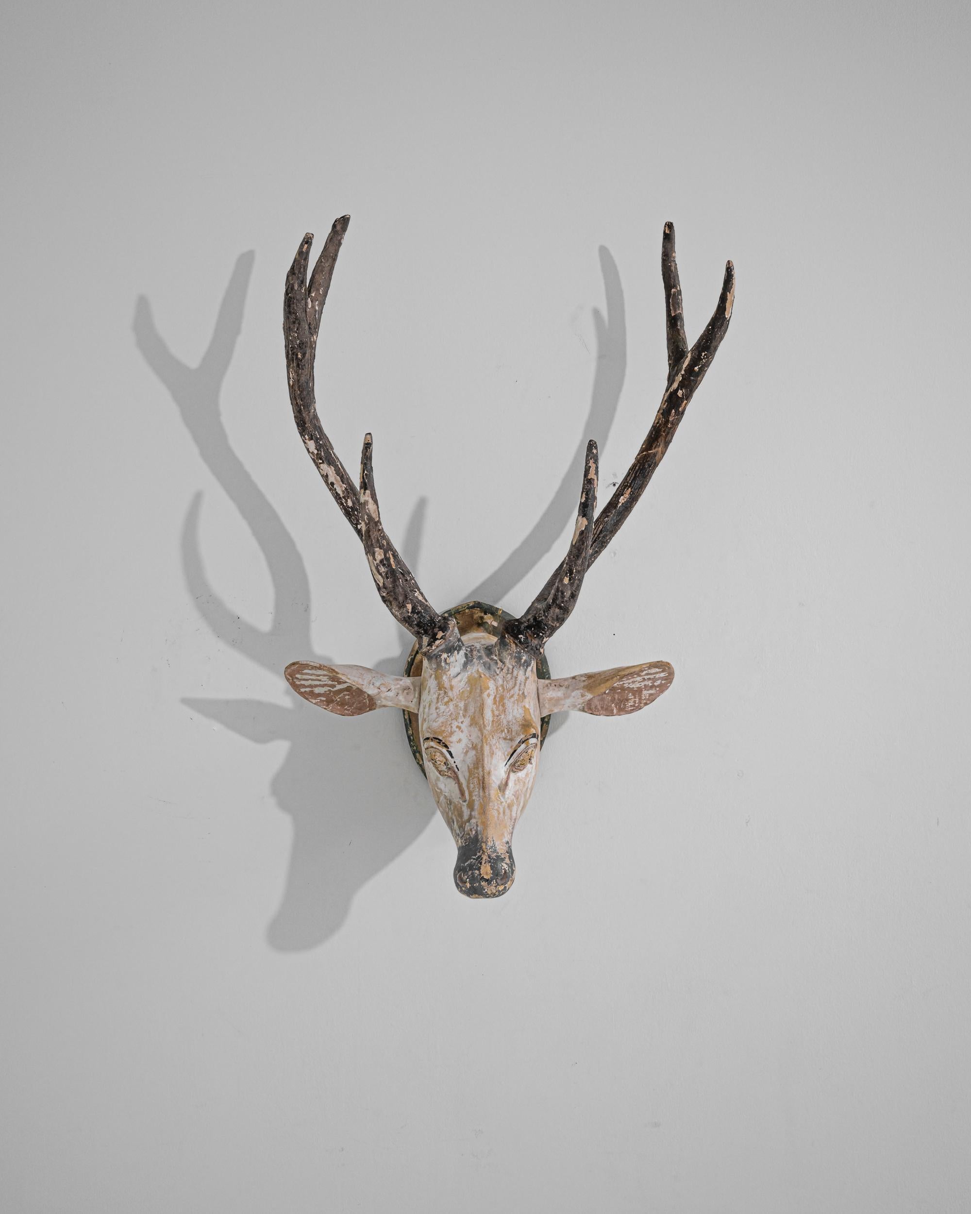 This rustic piece evokes the atmosphere of a hunting lodge in the Scandinavian forest. Made in the early 20th century, the carved form depicts a stag’s head, mounted on a wooden plaque. The shape is realistic, indicating that the craftsman was