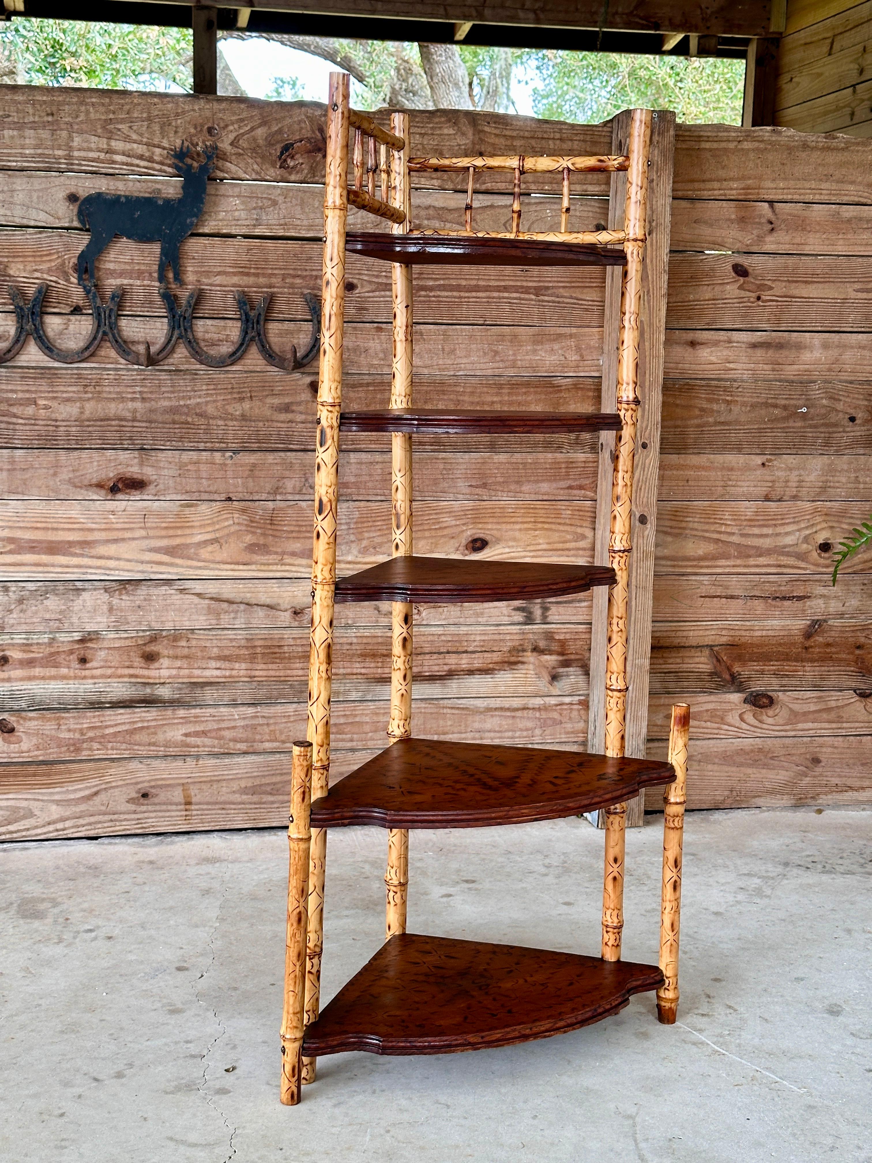 Scaffale angolare in bambù inglese scrostato dei primi del Novecento, completamente rifinito.
Questo pezzo elegante presenta intricati dettagli in bambù bruciacchiato lungo le gambe, mentre i ripiani in legno scuro offrono un ampio spazio di