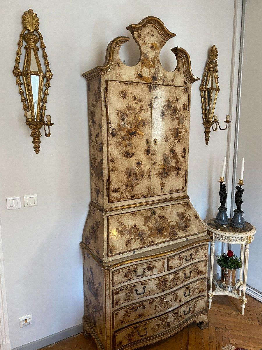 This two-part scriban cabinet showcases an exquisite combination of cream and gold Chinese lacquer, representing exquisite Italian craftsmanship from the early 20th century. The lower section is equipped with a chest of drawers featuring five