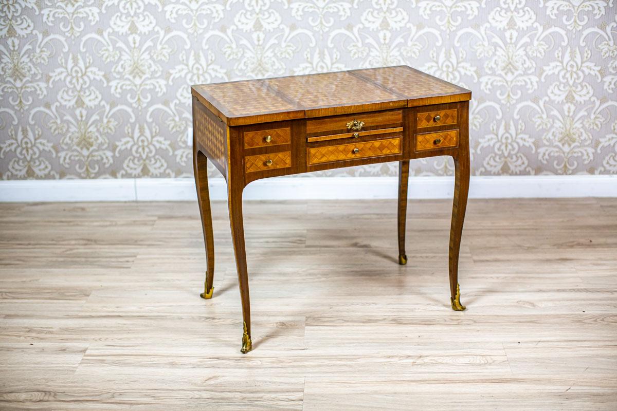 Early 20th Century Secretary Desk with Mosaic Parquet

The corpus is placed on high legs with brass appliqués on the feet.
The top covering the whole is divided into three parts.
The central section can be opened upwards. It hides a mirror on its
