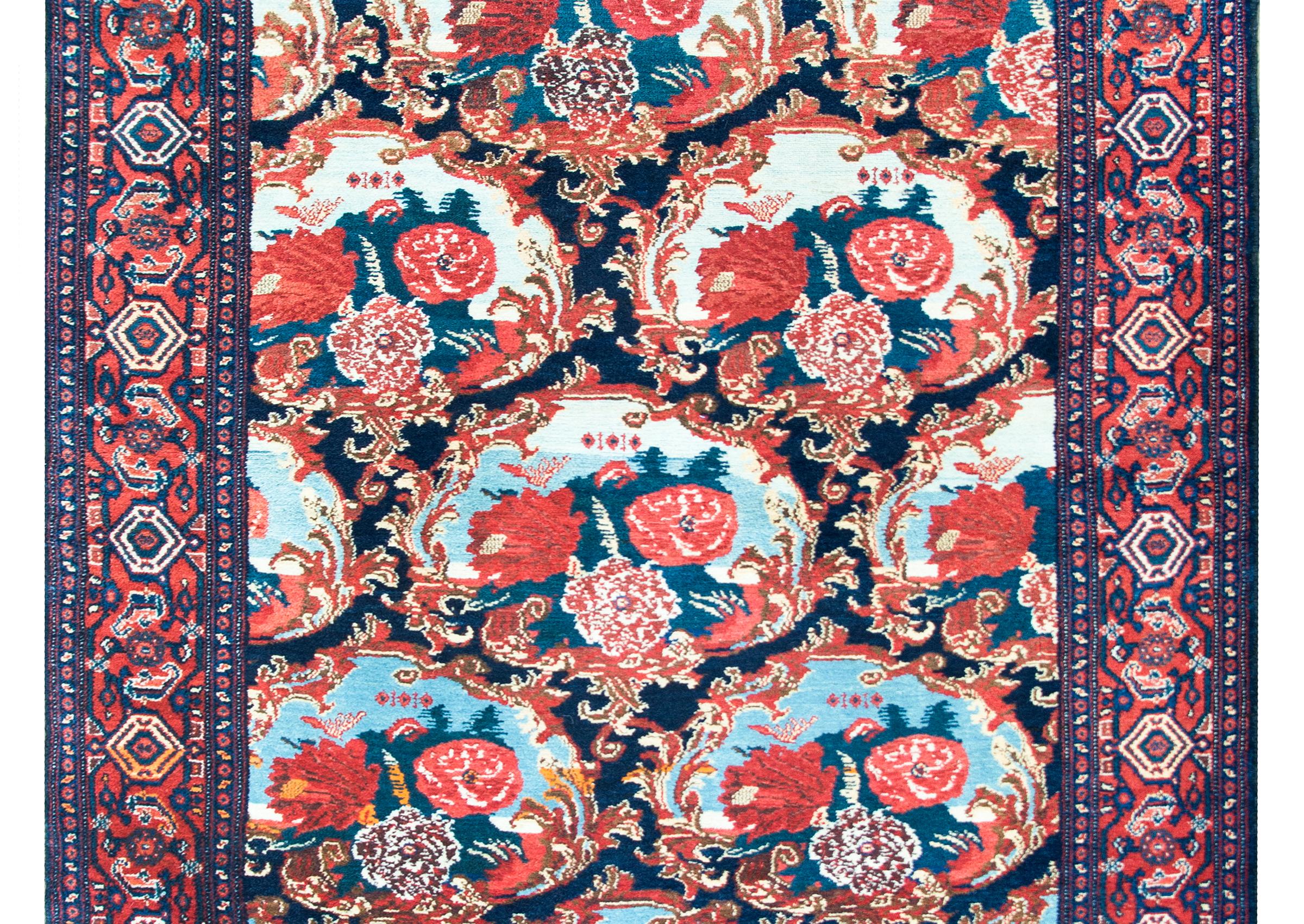 An incredible early 20th century Persian Senneh rug with the most beautiful large scale floral medallions each surrounded by baroque floral frames, and woven in brilliant crimson, pink, white, light and dark indigo, and all surrounded by a repeated