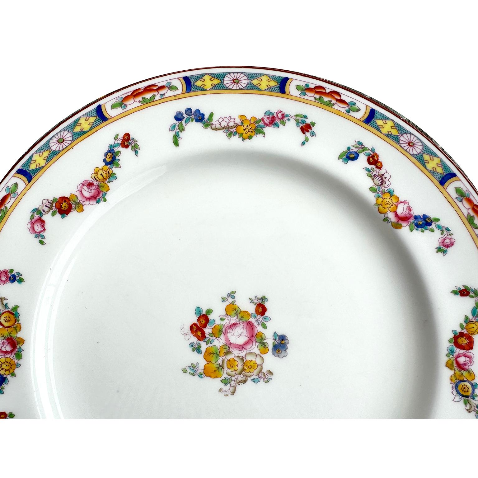A Set of 34 English Hand-Decorated Minton Fine China Dining Plates. The beautifully vibrant color hand painted dinner plates, each with a colorful floral design, an intricate trim and swaged floral strands, centered with a floral bouquet. All