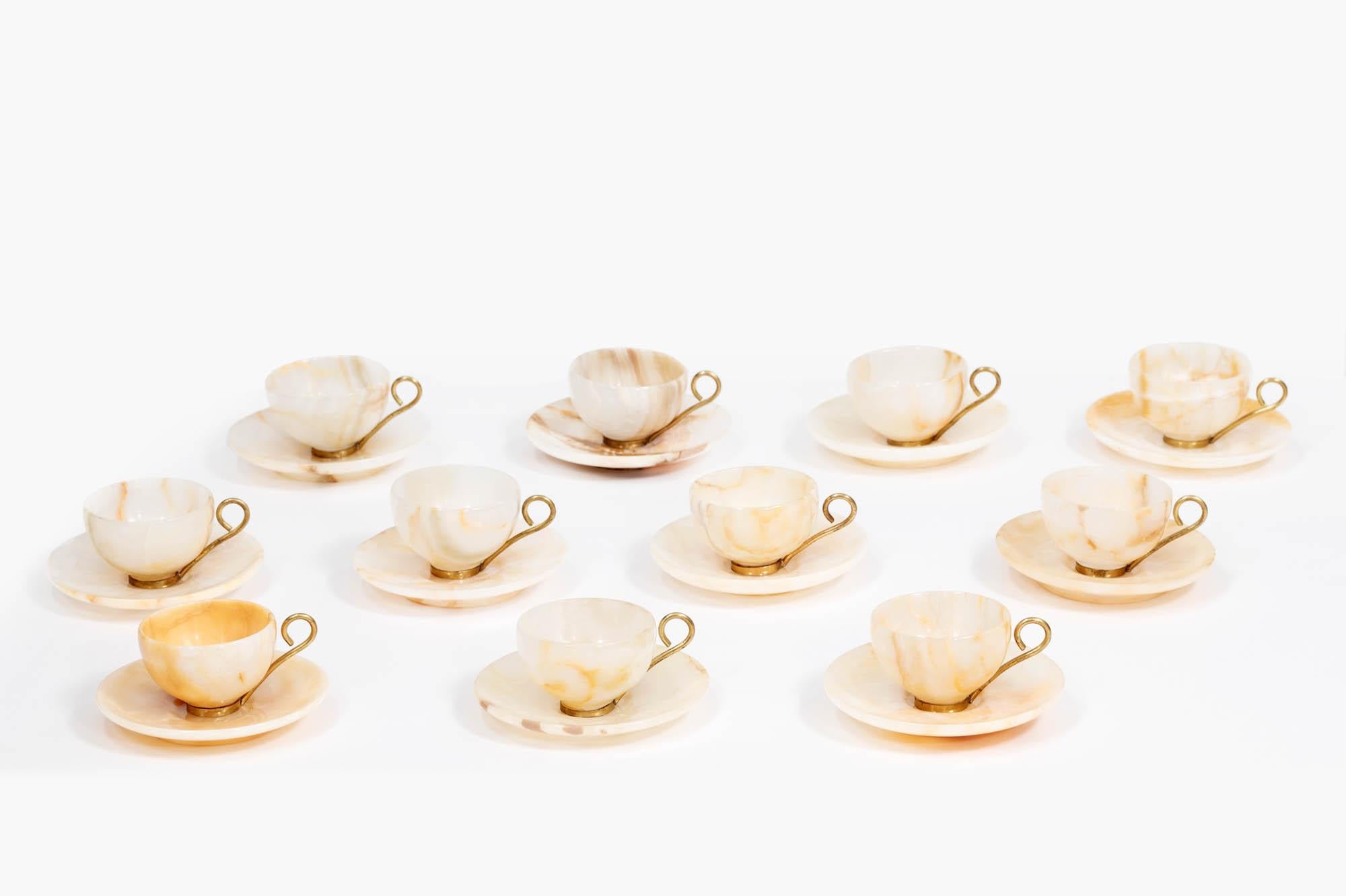 Early 20th Century set of eleven agate espresso cups and saucers complete with polished brass bases and handles. Likely Italian in origin, this set is exquisitely polished to a smooth finish with a delicate, thin transparency.