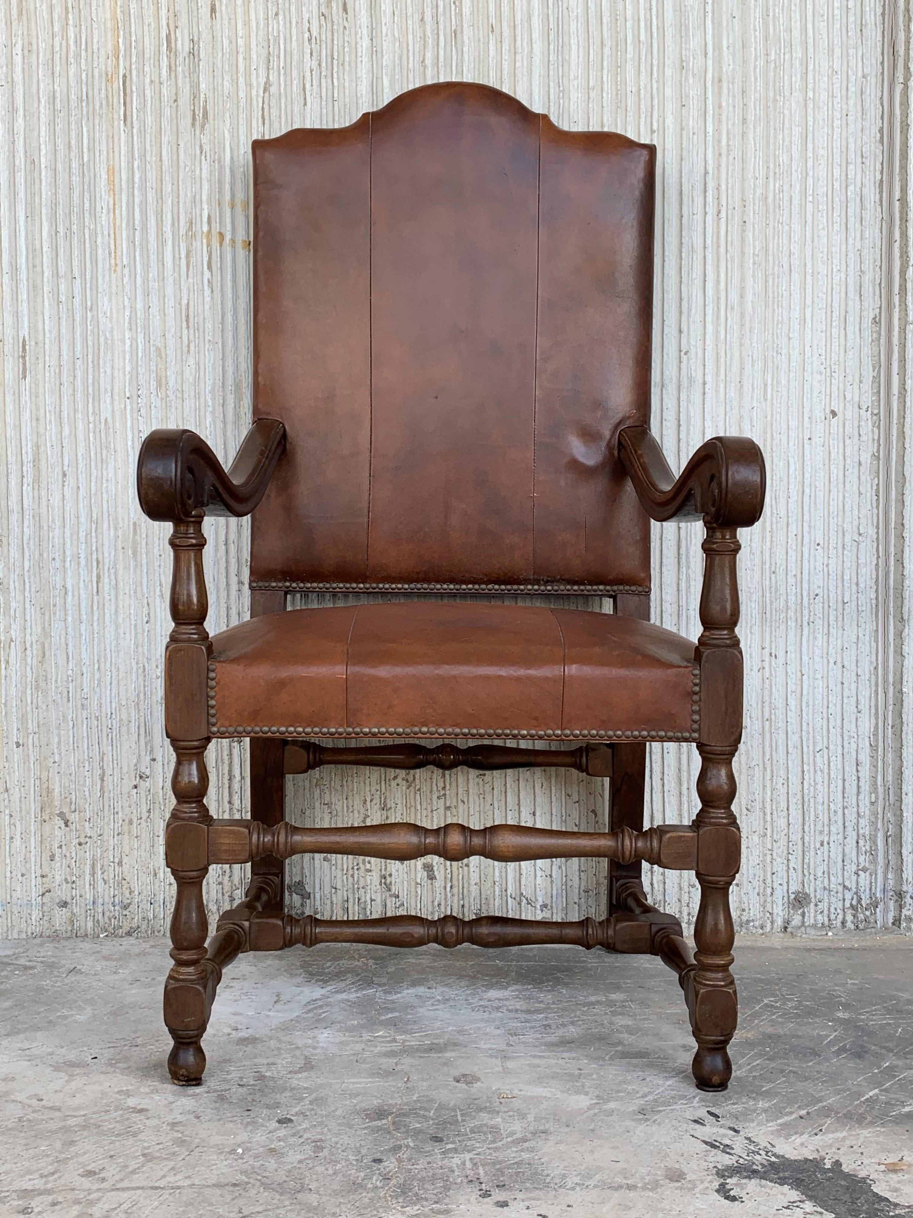 A 20th century Continental walnut set of two armchair s and six chairs with turned legs and stretchers upholstered in brown leather. 
The chairs are beautifully upholstered in brown colored leather with beautifully shaped backs and baseball