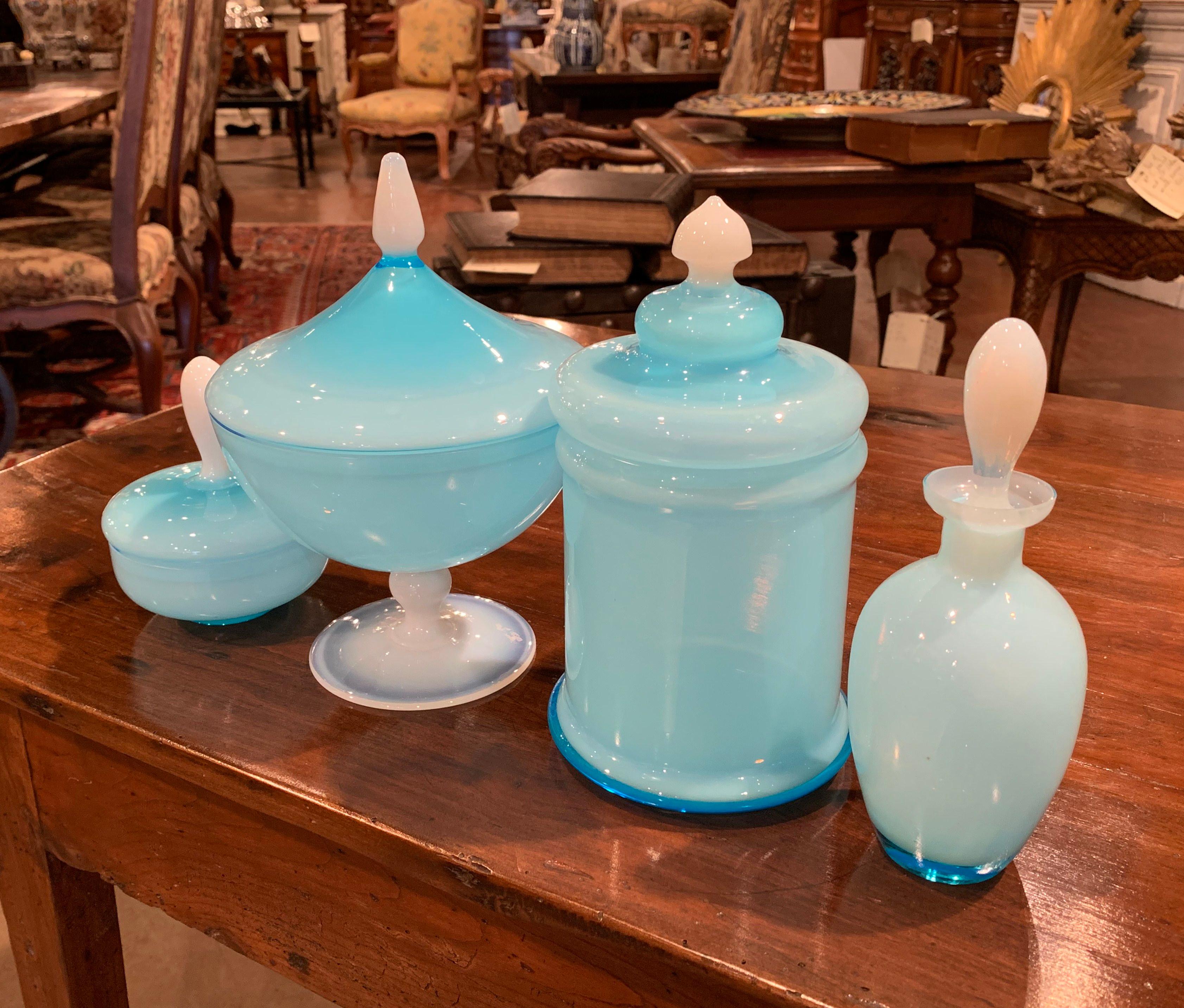 Decorate a master bathroom with this colorful, well-preserved set of opaline glass bottle and jars with tops. Hand blown in France, the blue glass set includes a perfume bottle, an apothecary jar, a cup and a storage box for make-up or cotton balls.