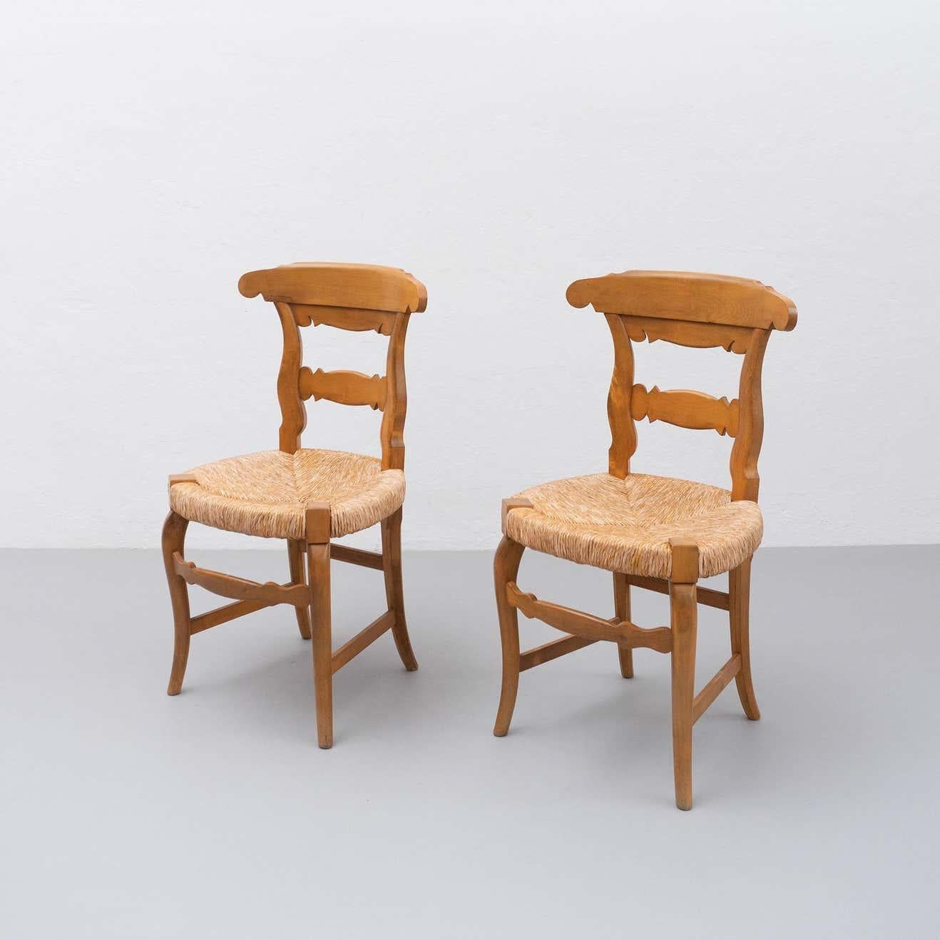 Ensemble de deux chaises provençales du début du 20e siècle. Chaises en bois avec une assise traditionnelle en rotin, des lignes courbes et des détails caractéristiques du style provincial français.

En bon état d'origine, avec une usure mineure