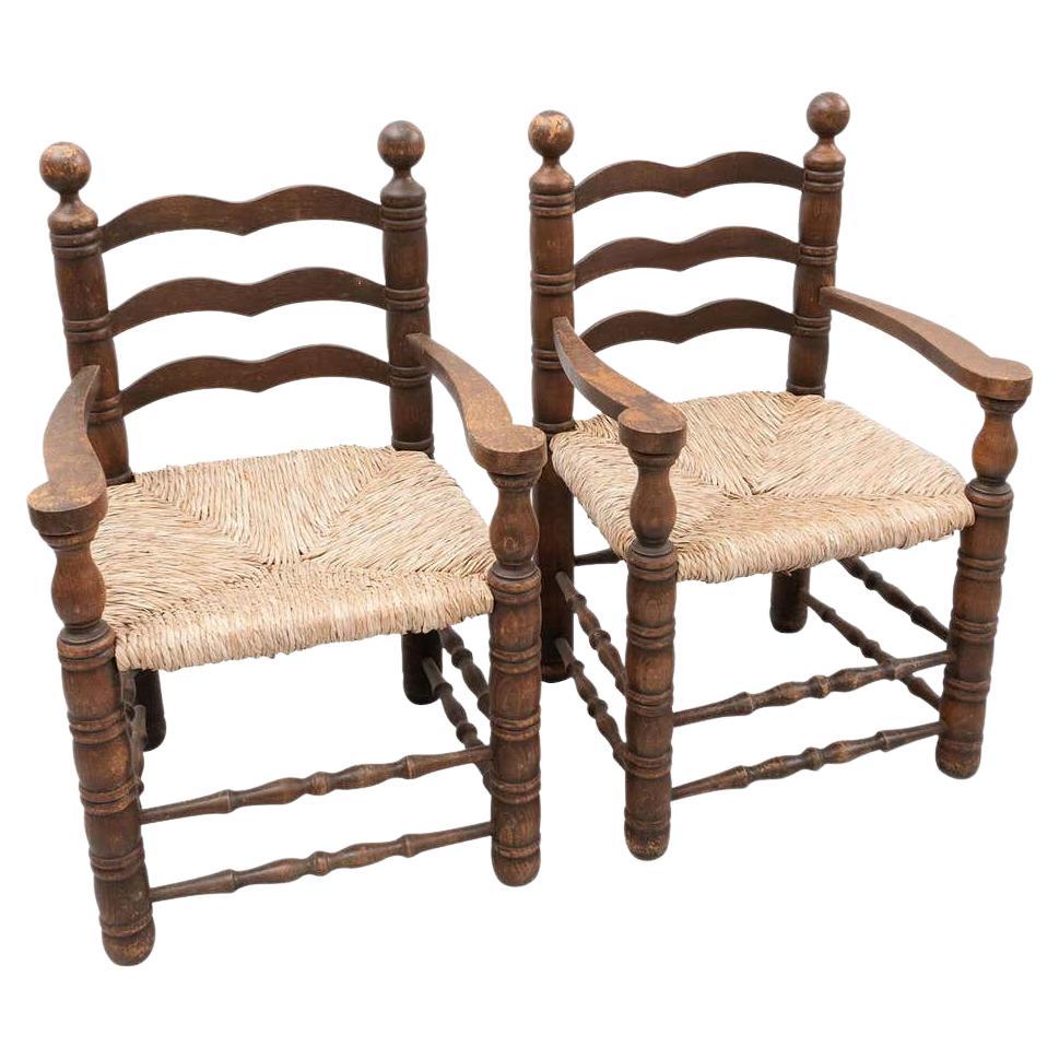 Set of two popular rustic armchair by unknown manufacturer from Spain, circa early 20th century.

In original condition, with minor wear consistent with age and use, preserving a beautiful patina.

Materials:
Wood and rattan 

Dimensions:
D 52 cm x