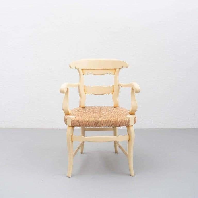 Set di due poltrone provenzali dei primi del Novecento. Poltrone in legno con un'ampia seduta tradizionale in rattan, linee curve e dettagli caratteristici dello stile provinciale francese.  Dipinto in crema, alcune gambe mostrano i segni dell'età e