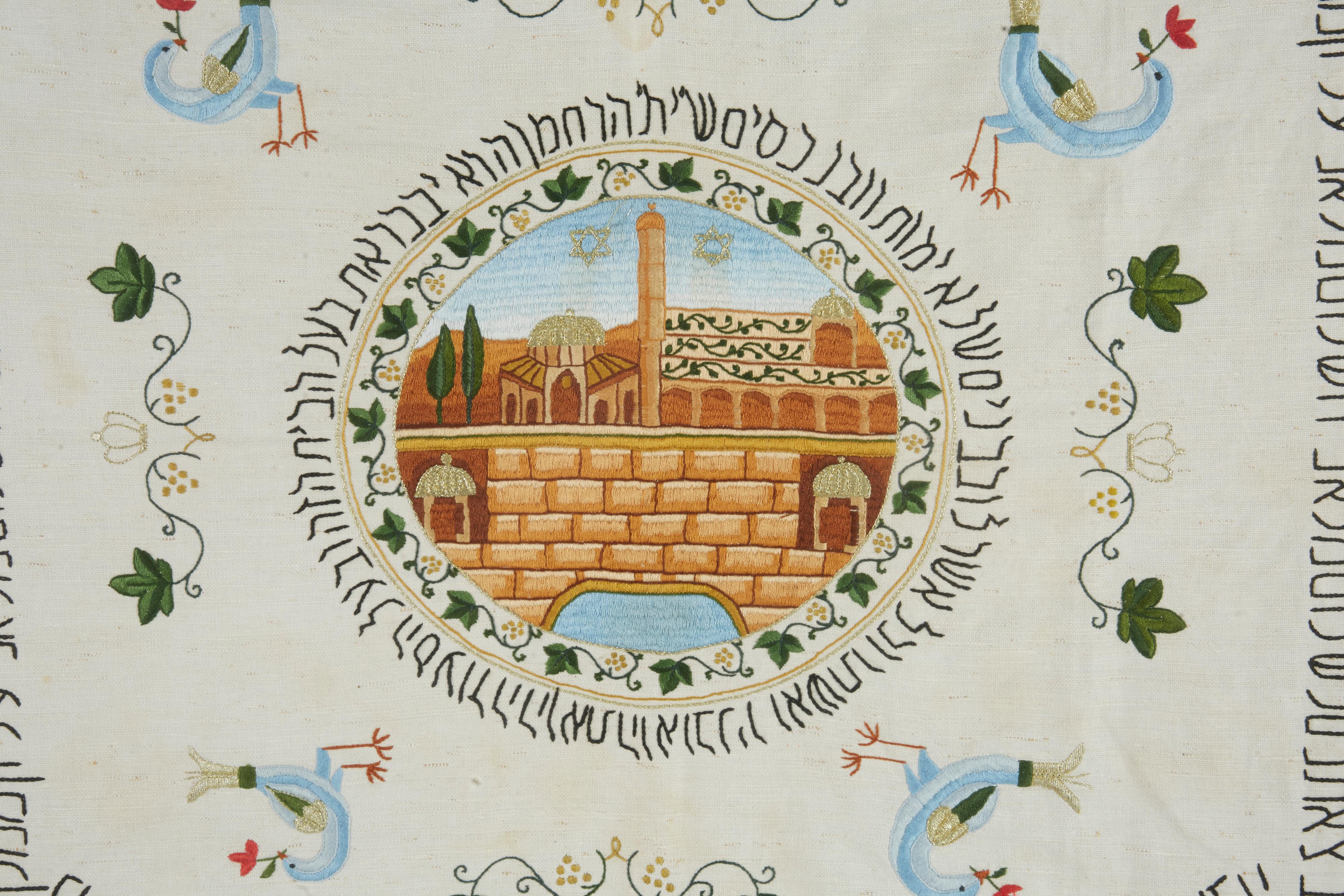 Folk Art Shabbat table cover, Jerusalem, circa 1900.
Embroidered at the four corners with the holy places for Jews in Israel, and with the wailing wall at the center.
The Hebrew rectangular text is a traditional song sung by Jews every Friday