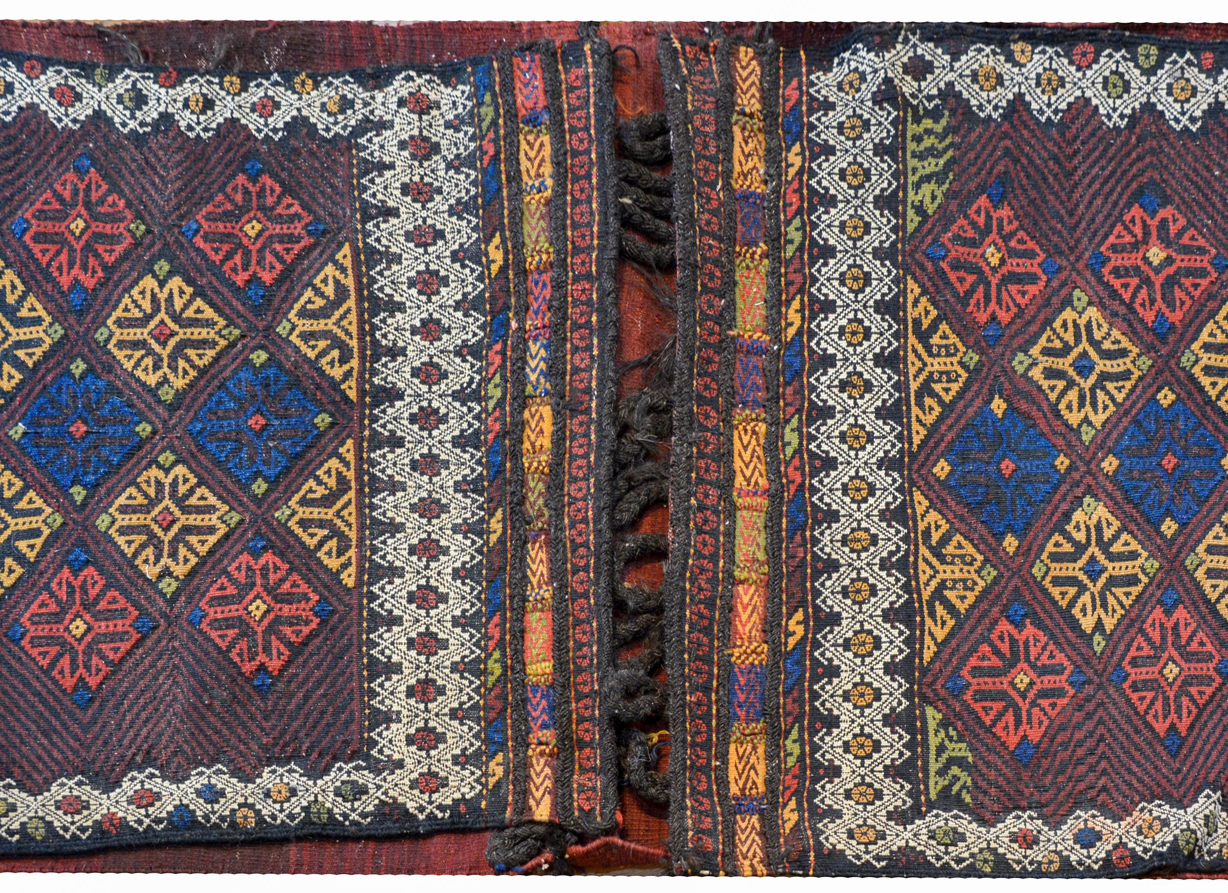A wondeful early 20th century Persian Shahsevan flat-weave saddlebag with a fantastic multicolored diamond pattern surrounded by a wide white geometric pattern. The back side is woven in varying shades of crimson and indigo.