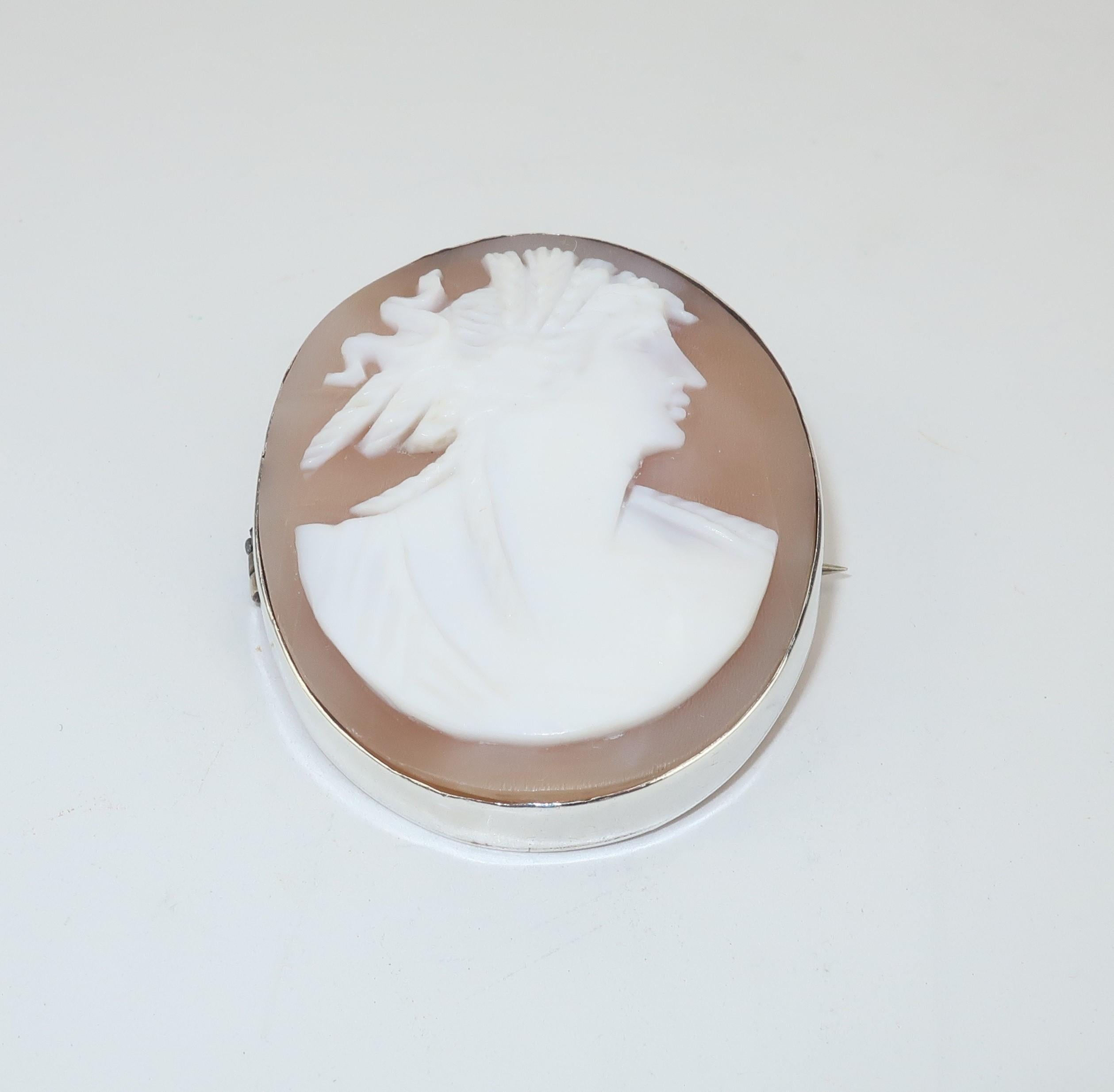Cameos are true pieces of artistic portraiture often depicting old world ethereal beauty and providing nostalgic charm to modern wardrobes.  This early 1900's carved shell cameo depicts a beautiful woman with a goddess aesthetic including an