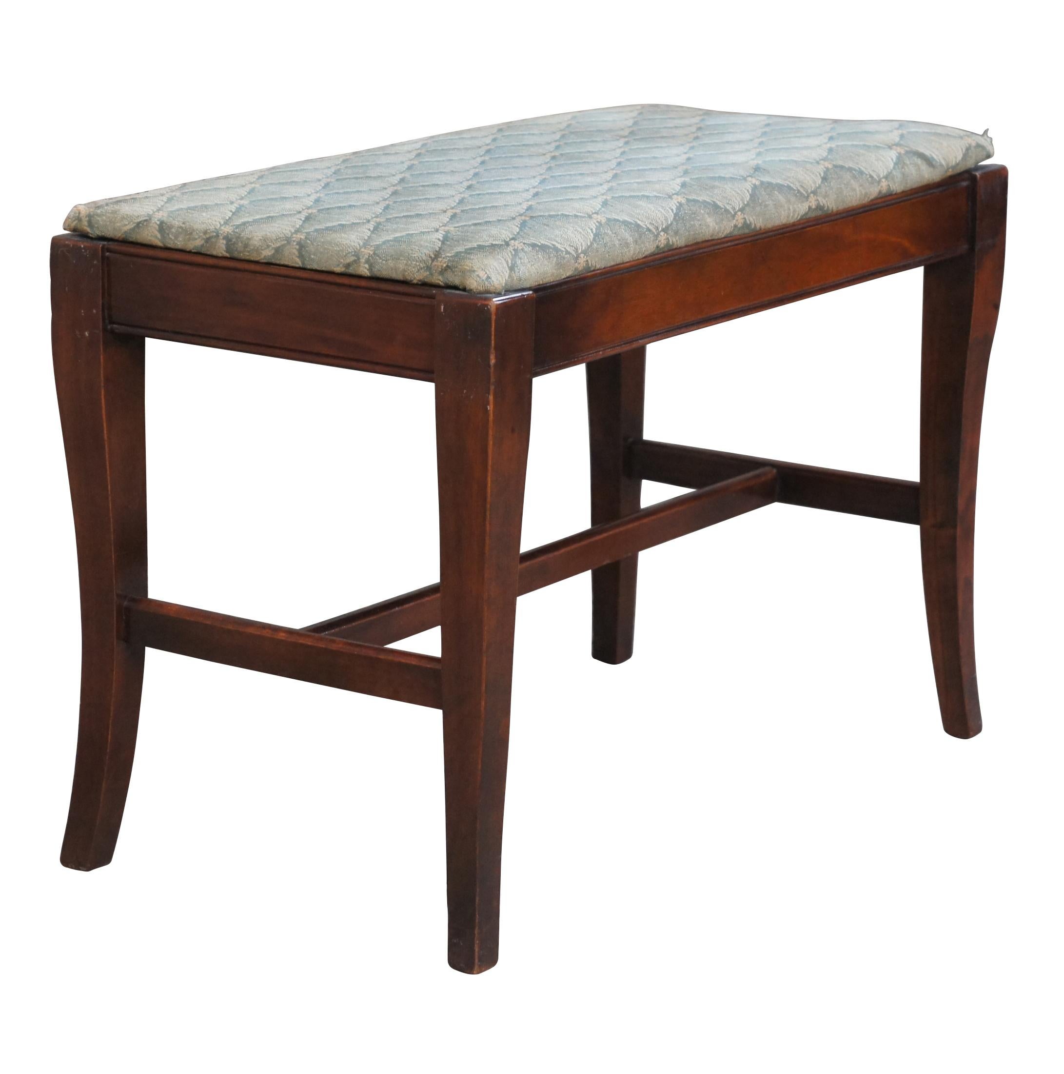 An early 20th century mahogany bench.  Features an upholstered seat and contoured legs connected by an H stretcher.

