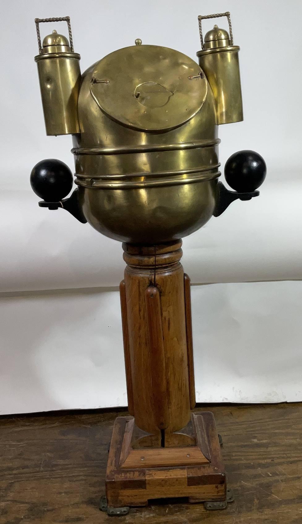 Binnacle de bateau sur piédestal en bois. Le binnacle lui-même est un bol en laiton avec un couvercle qui contient deux lampes à huile avec des brûleurs en porcelaine. Les billes de compensation en fer sont montées sur des supports en laiton. Le