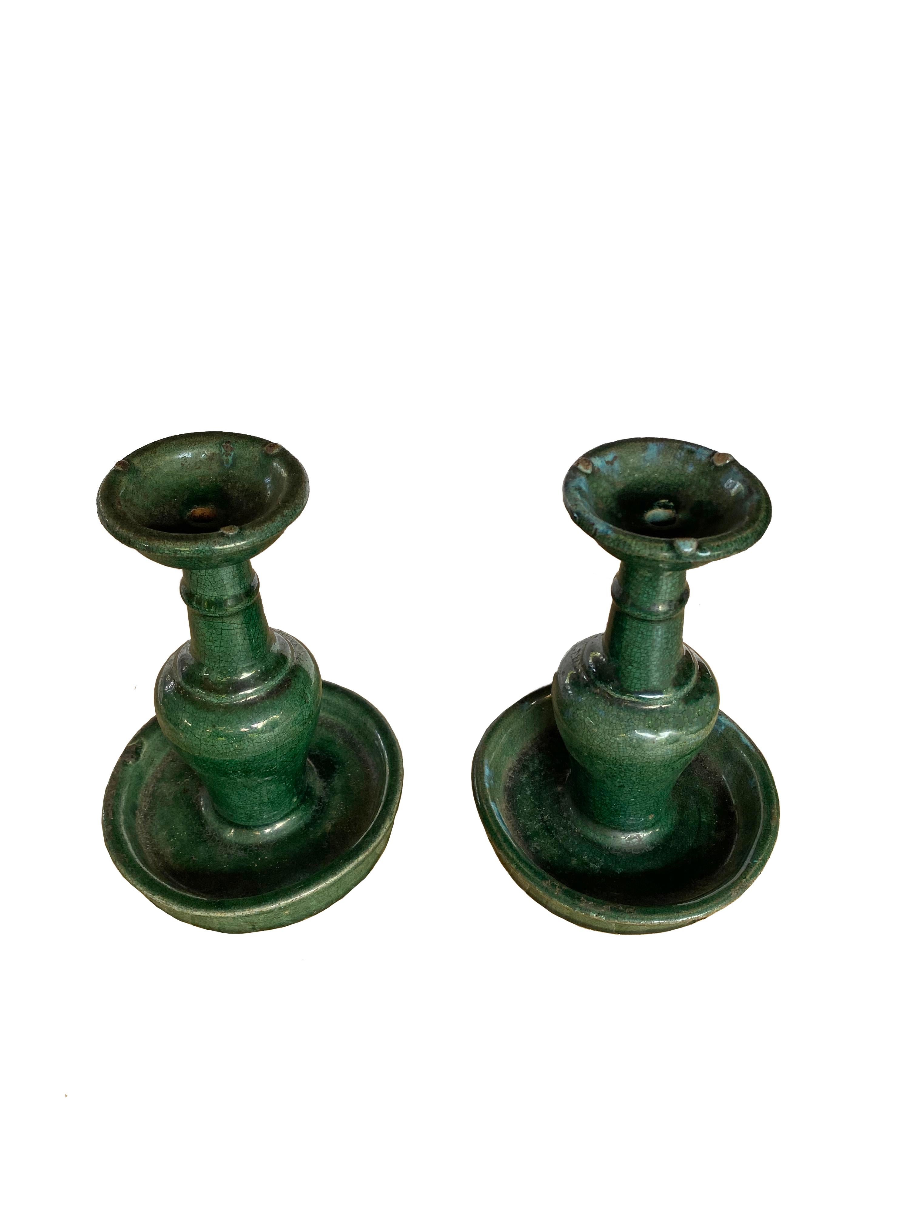 This set of Shiwan ware oil lamps from the early 20th century features the distinctive green glaze. Shiwan ware is a style of Chinese pottery from the Shiwanzhen district near Guangdong, China. 

Measures: Diameter 13cm x Height 17cm.
   