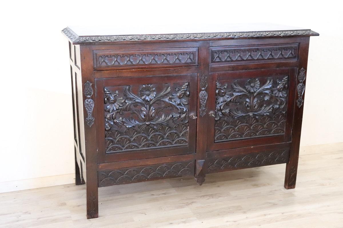 This early 20th-century beech wood sideboard is a stunning example of timeless craftsmanship and design. The front of the piece is adorned with intricate wood carvings, featuring a rich display of floral motifs that make an immediate impression.