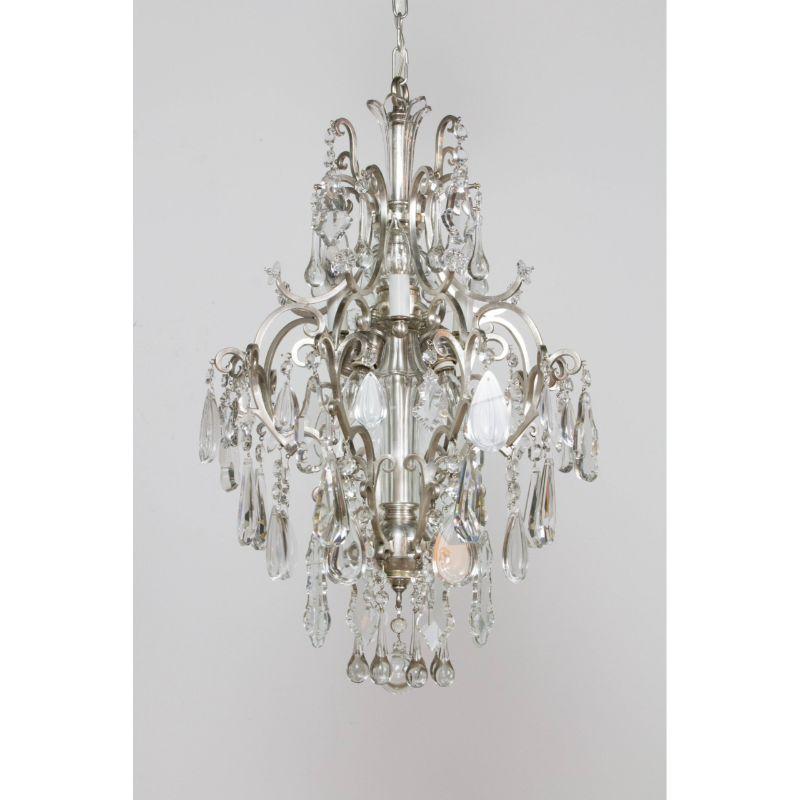 An ornate cage style chandelier made of silver plate and crystal. Attributed to E.F. Caldwell. C. 1910. This stem of the chandelier is silver plated brass, and is alternating silver stempieces and cut crystal balls and stem pieces. The chandelier is