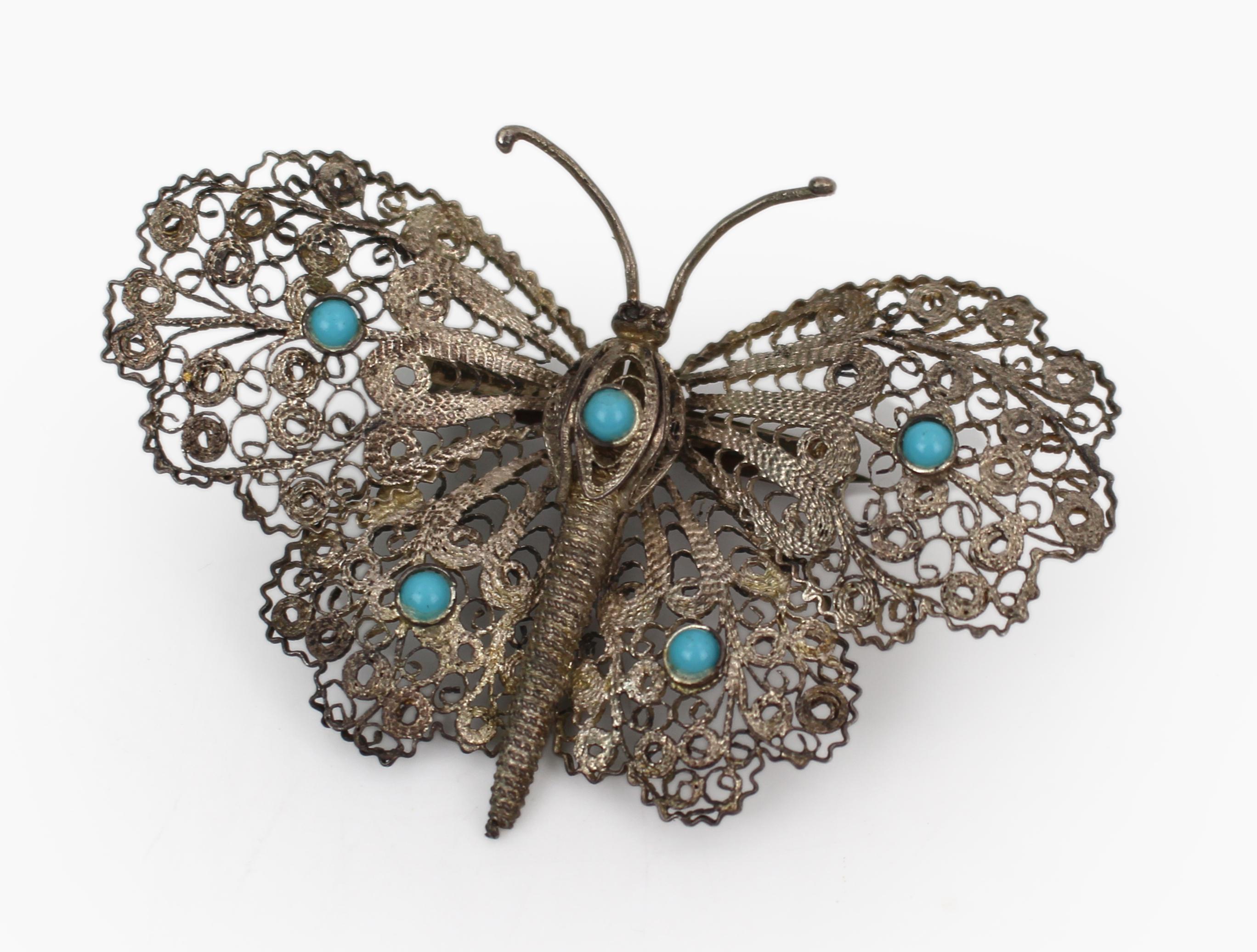 Broche papillon en filigrane d'argent maltais du début du 20e siècle avec cabochons de turquoise

Broche papillon en argent filigrané finement travaillée, datant du début du XXe siècle et probablement d'origine maltaise, où le travail de l'argent