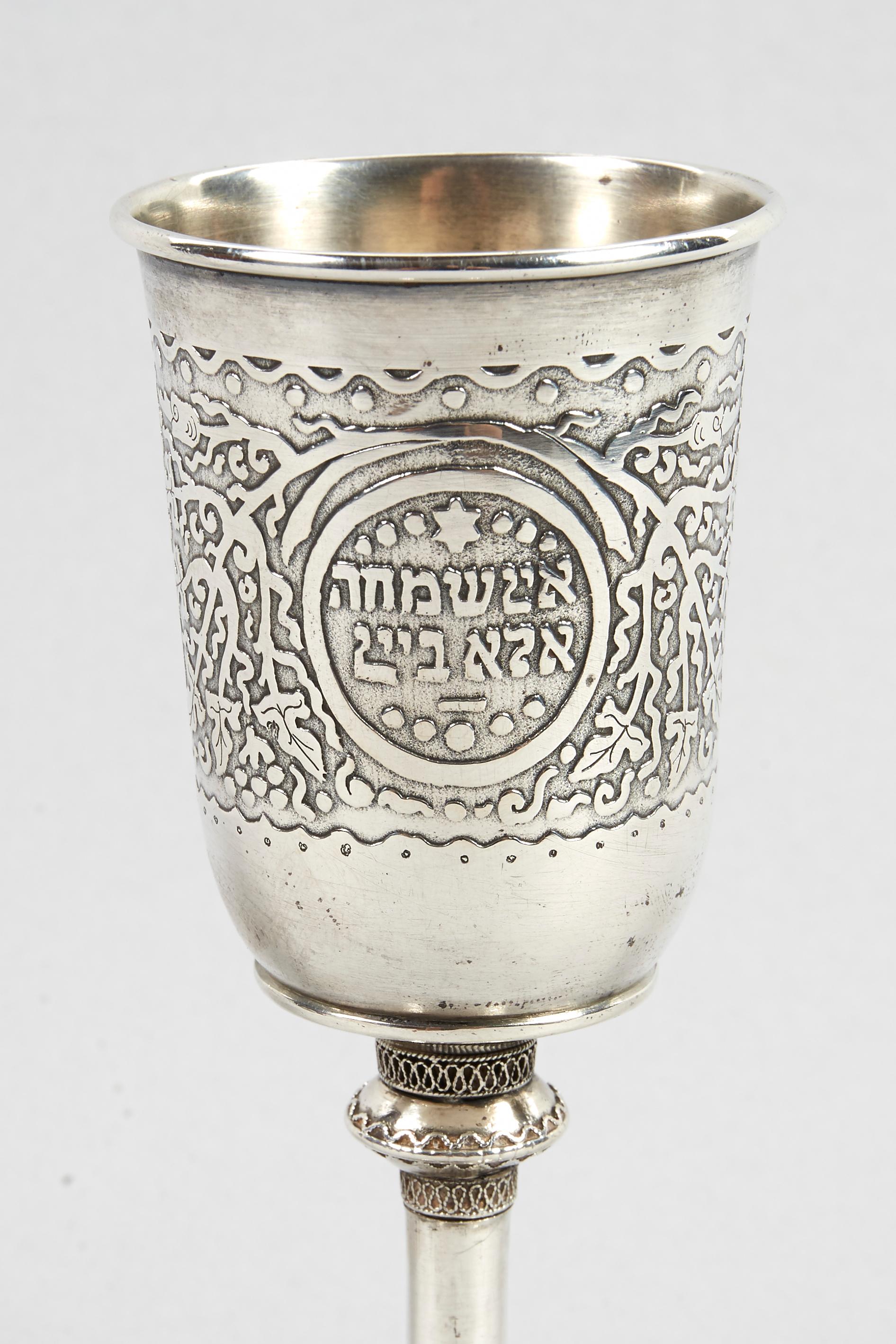 Sterling silver Kiddush goblet by Bezalel School, Jerusalem, circa 1918. 
Decorated with acid etched with vine and acanthus scrolls, and with silver filigree. Inscribed in Hebrew: 