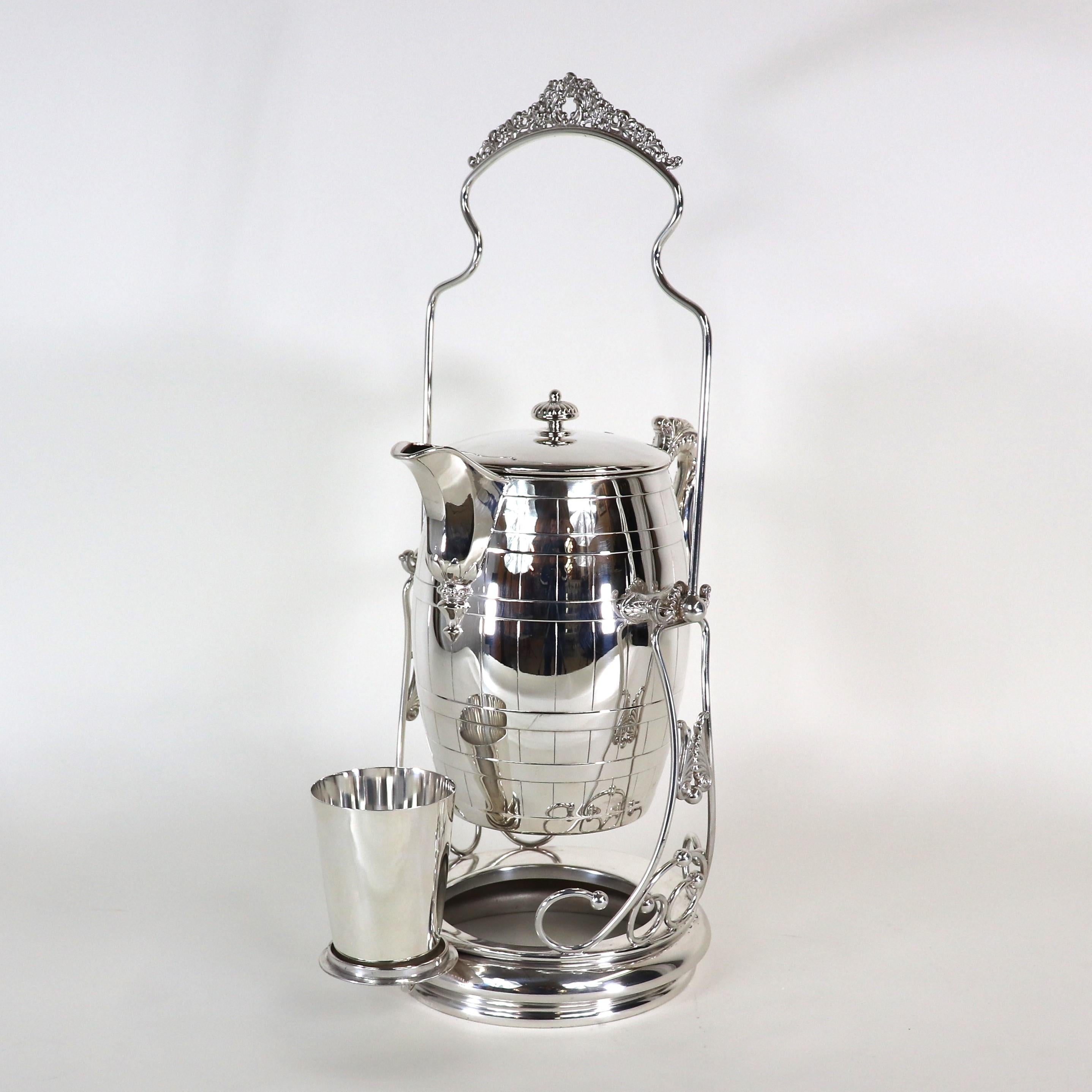 Serve any beverage of your choice with elegance with this silver-plated decanter beverage pitcher jug drink cask by the Standard Silver Company of Toronto Canada. The ten-cup set comes with a stand, pitcher, and slop cup. The inside has a porcelain
