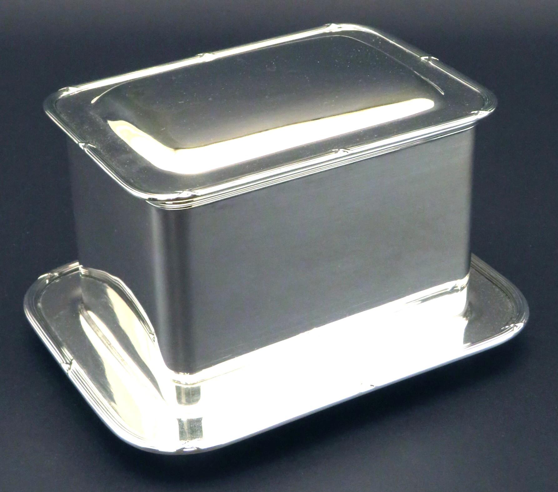 A very handsome silver plated biscuit box or humidor of timeless design, having a rectangular body with a hinged and partially domed lid trimmed with a neoclassical inspired reeded edge, overtop a conforming flat raised on four compressed bun feet.