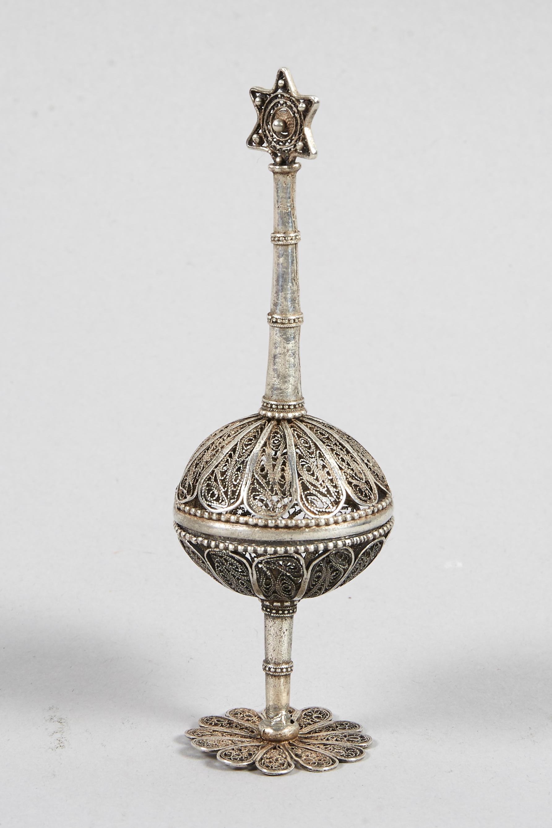 Silver and silver filigree spice container, Jerusalem, circa 1920. 
Ball spice container raised on a stem, on a flat filigree foot, the lid is surmounted by a Star of David.
Typical Bezalel school design. 


