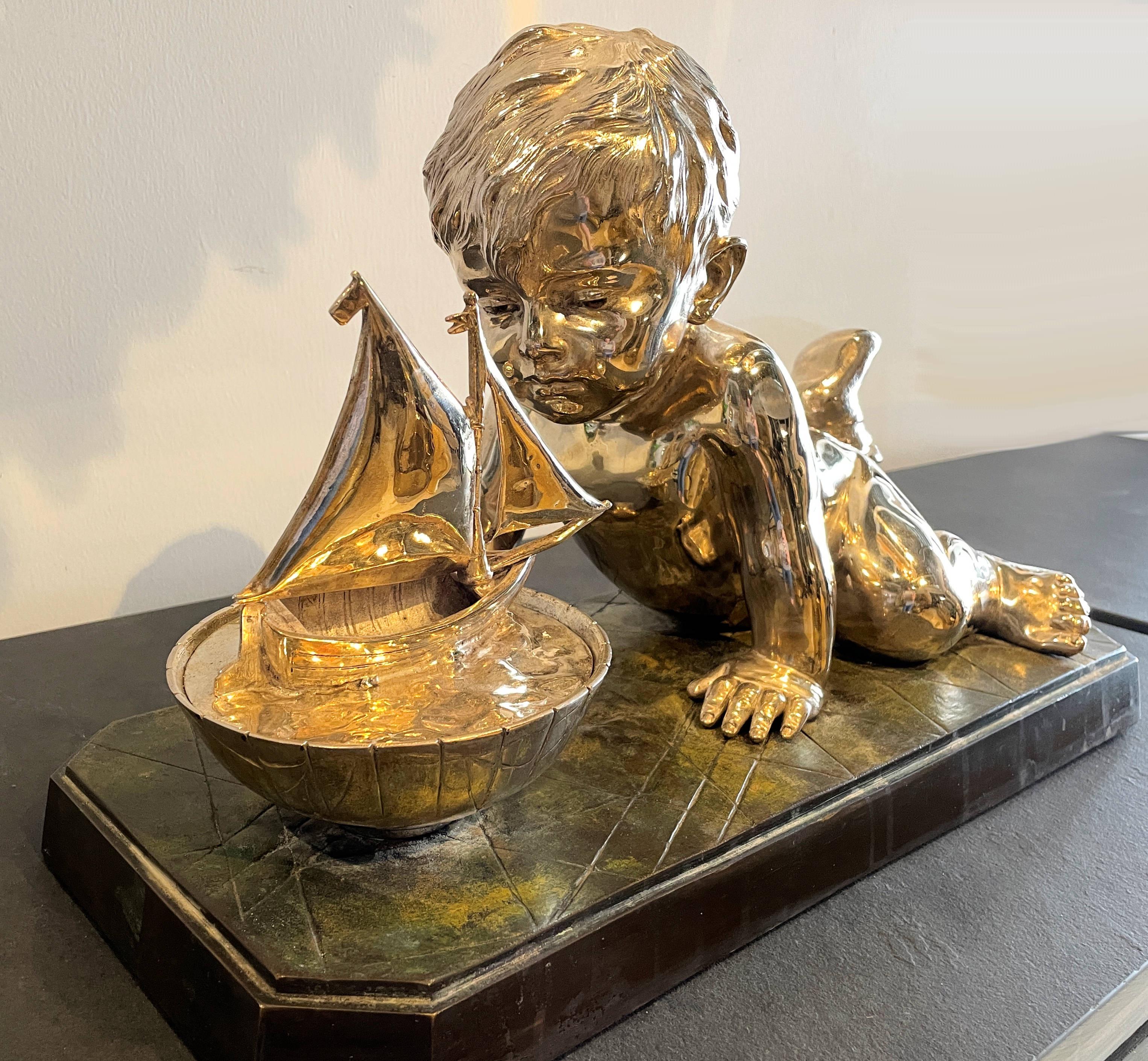 Silvered bronze on marble of a young child playing with a toy boat, signed Villanis, Emmanuel Villanis, 1858-1914, France.