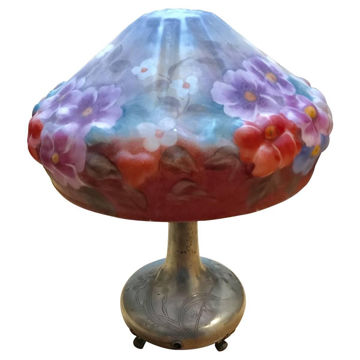 Pairpoint Manufacturing Company was founded by Thomas J. Pairpoint in 1880 in New Bedford, Massachusetts. Whimsical and one-of-a-kind, this Art Nouveau-style lamp is composed of a silver plated Stand and a frosted glass shade. Claw feet and colorful