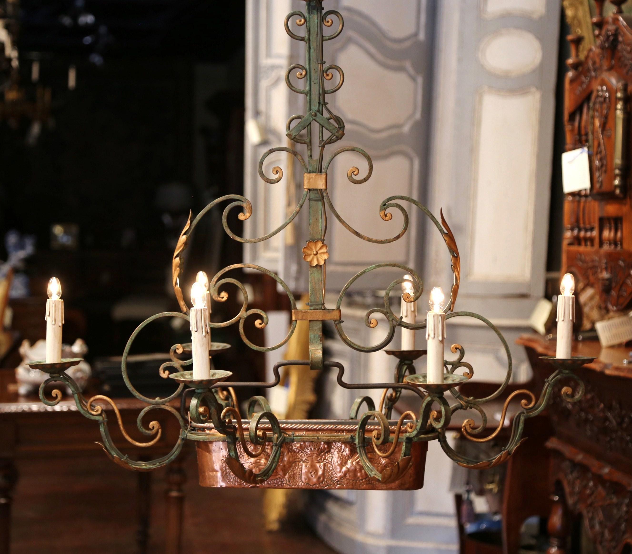 This interesting, antique chandelier was crafted in France, circa 1920. The Classic French light fixture features a copper jardinière with repousse fleur-de-lis decor on one side, and a coat of arms on the other. The chandelier is outfitted with new