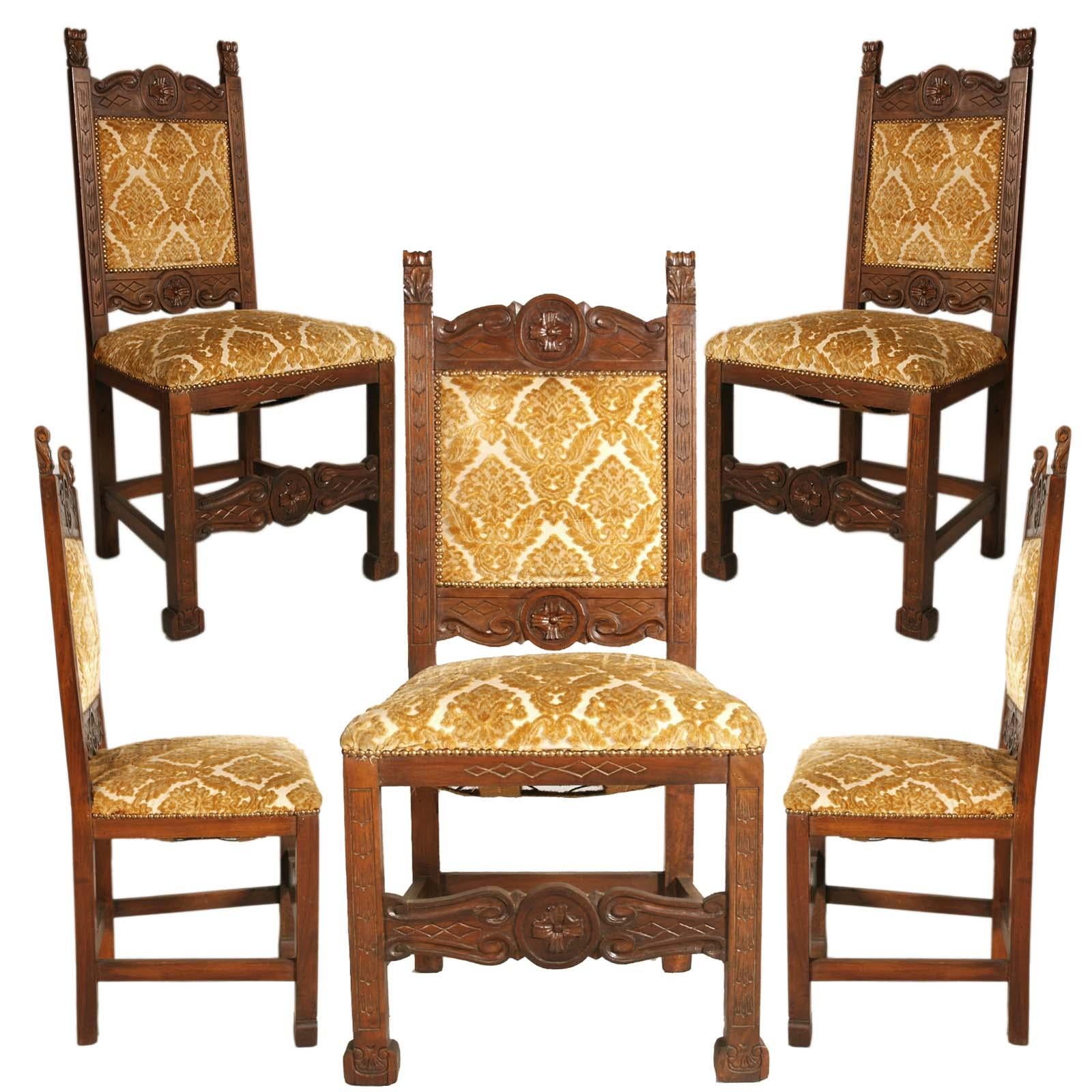 Italian Tuscany early 20th century six Renaissance chairs, in solid walnut, richly hand carved, Dini e Puccini attributed. Back and seat ocher velvet upholstered with original straps and springs of the era in good condition. 
Restored and wax