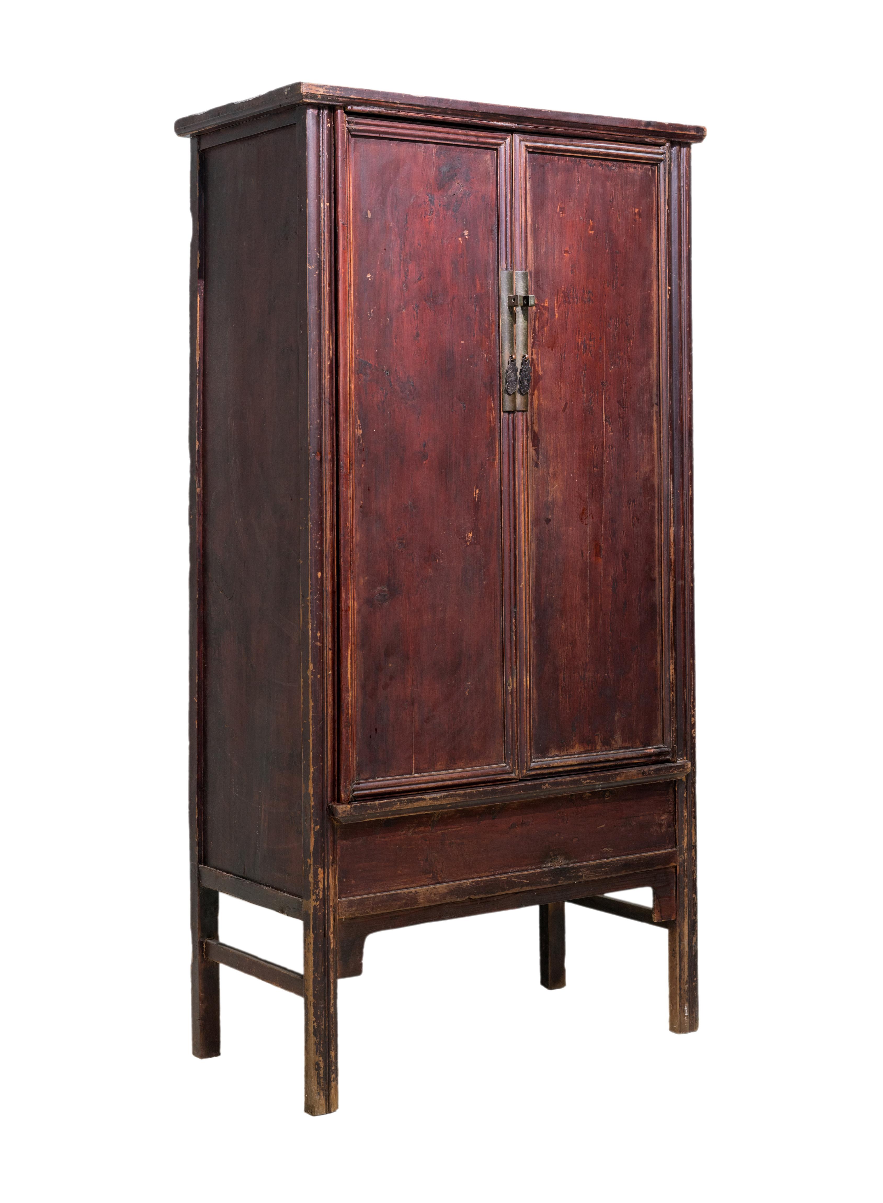 A deep red sloping-stile cabinet from Zhejiang province, China. Both legs are adorned with a single 