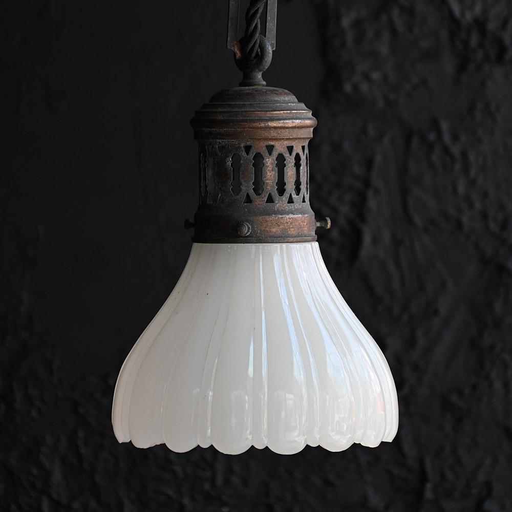 Early 20th Century Small Brass and Glass Ceiling Light

Still attached to its original brass ceiling rose and chain this diminutive milk glass light shade is rewired and ready to use. Aged well with a deep dark patina and highly decorative glowing