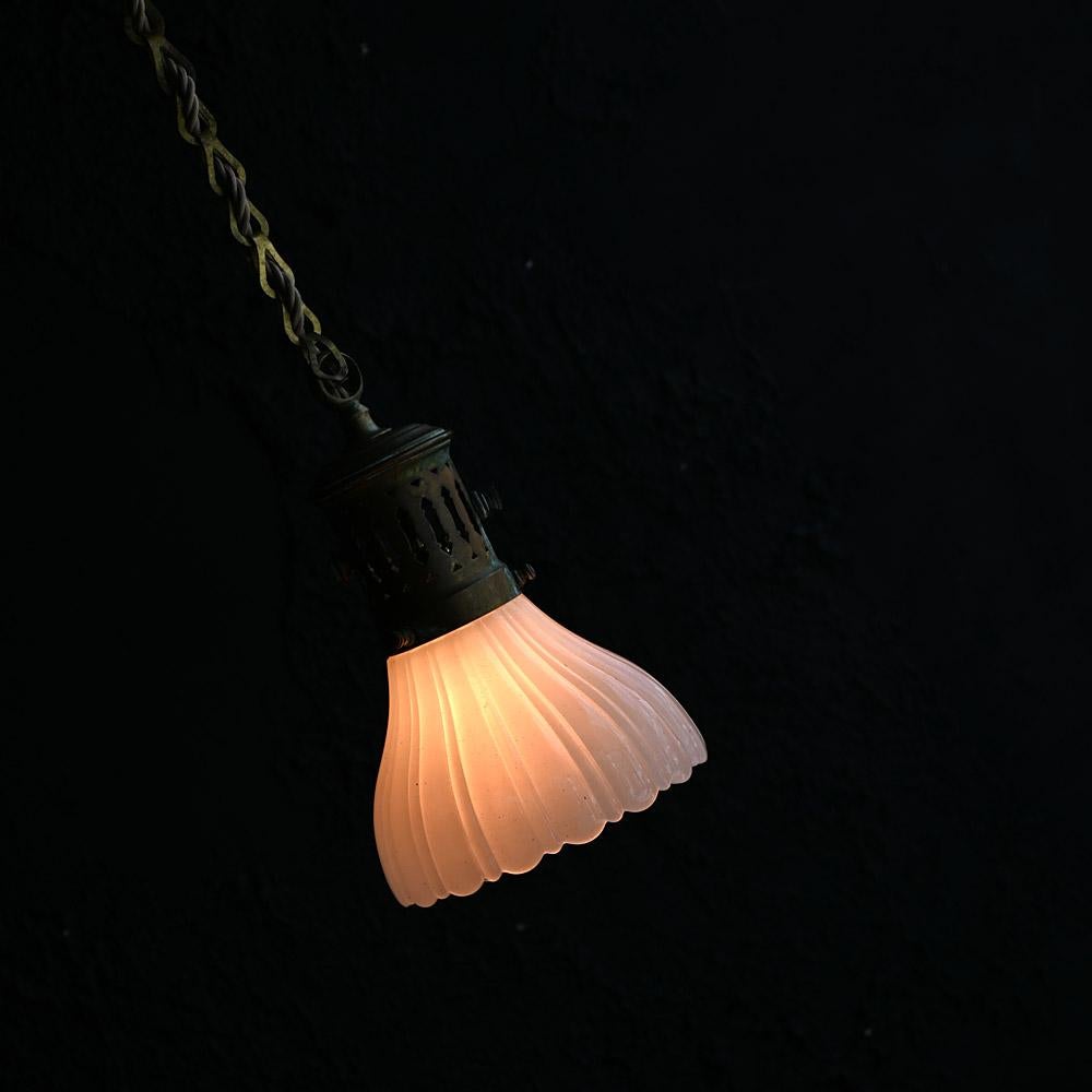 Early 20th Century Small Brass and Glass Ceiling Light
Still attached to its original brass ceiling rose and chain this diminutive milk glass light shade is rewired and ready to use. Aged well with a deep patina and highly decorative glowing visual