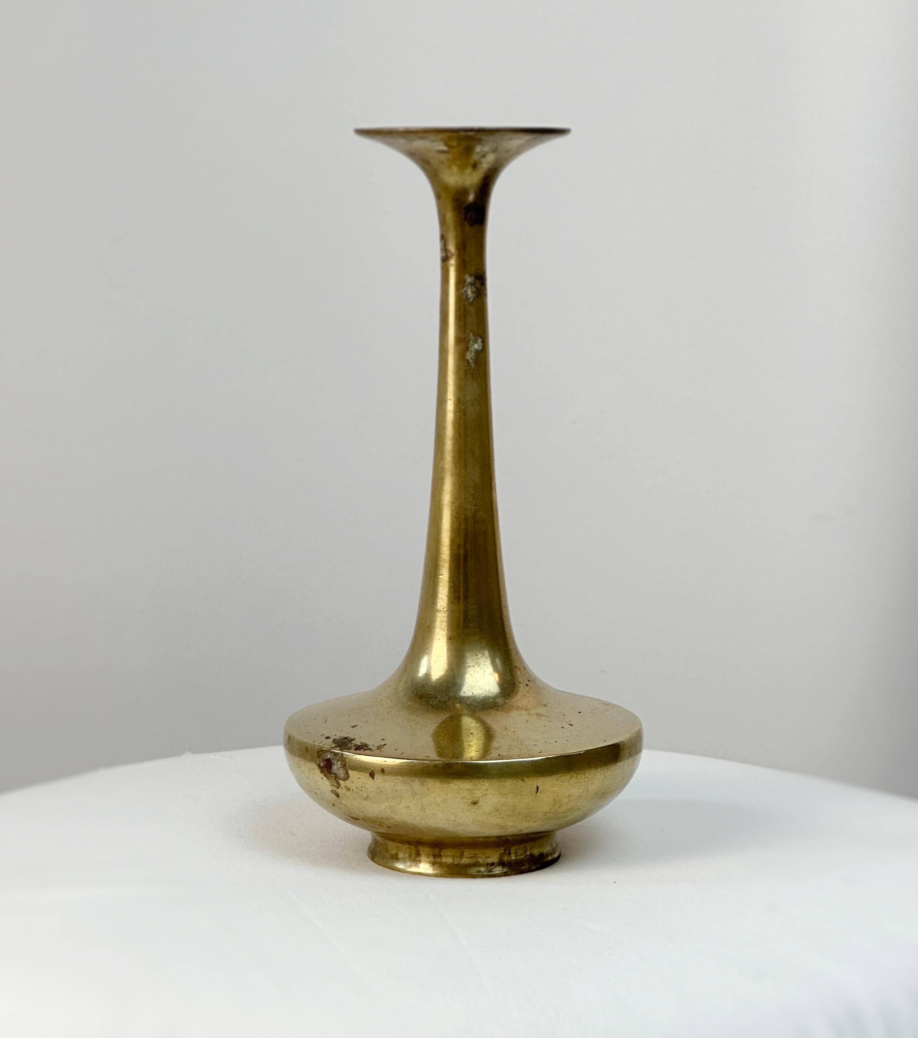 Introducing an exquisite Japanese brass ikebana bud vase from the early 1920s

This elegant vase is a testament to Japanese craftsmanship, capturing the essence of simplicity and refinement. Crafted from brass, it exudes a warm, inviting glow that