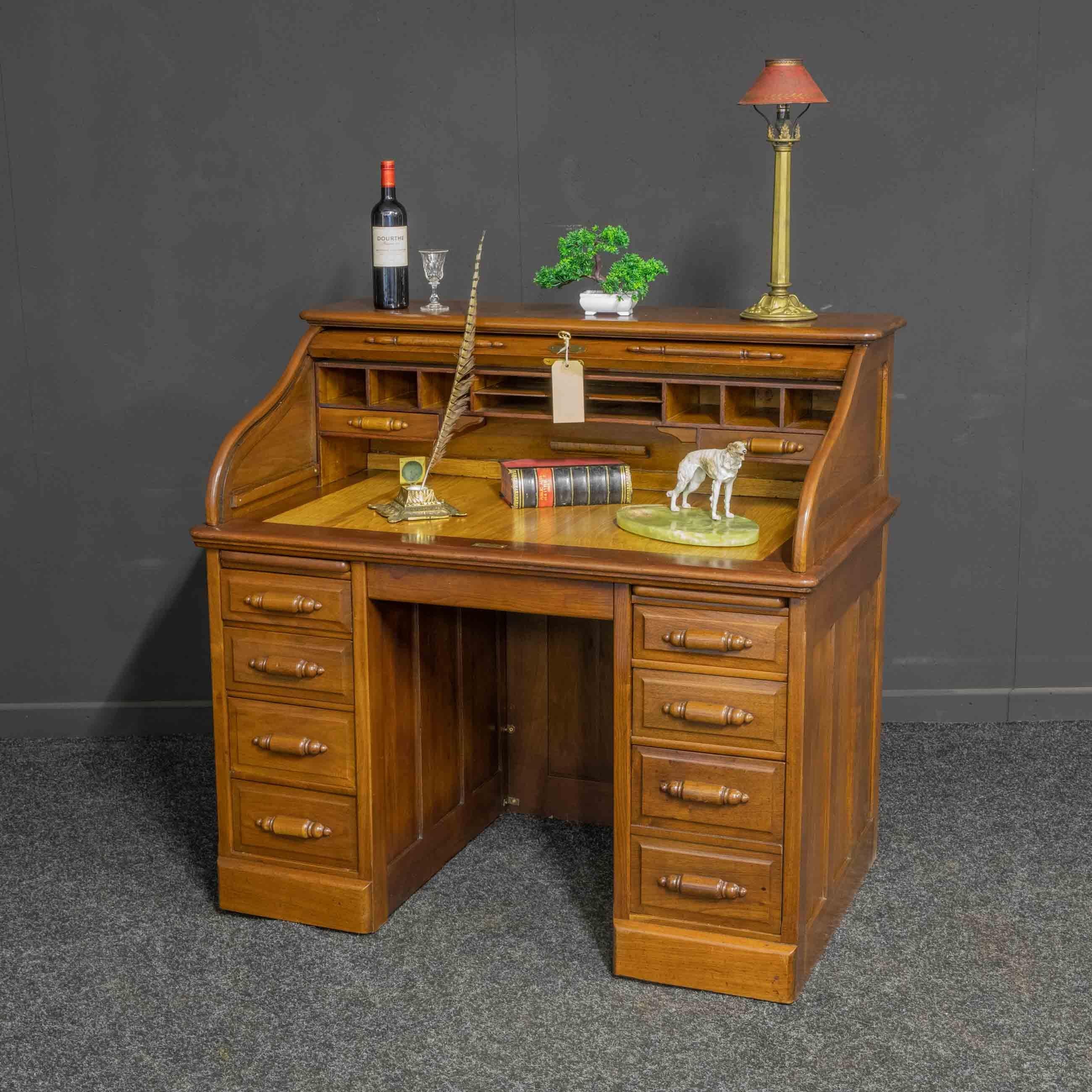 A small Edwardian roll top desk of the attractive proportions. Mostly solid walnut and in excellent condition re-polished approximately five years ago. The base pedestals have seven drawers, the bottom right being double height, all with the