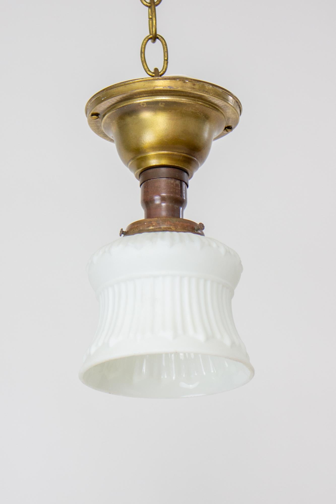 Early 20th century small white glass neoclassical revival flush pendant. Matte white relief glass in a classical pattern. Simple brass flush mount pendant. Rewired and ready for installation in the US. Glass in very good condition with some