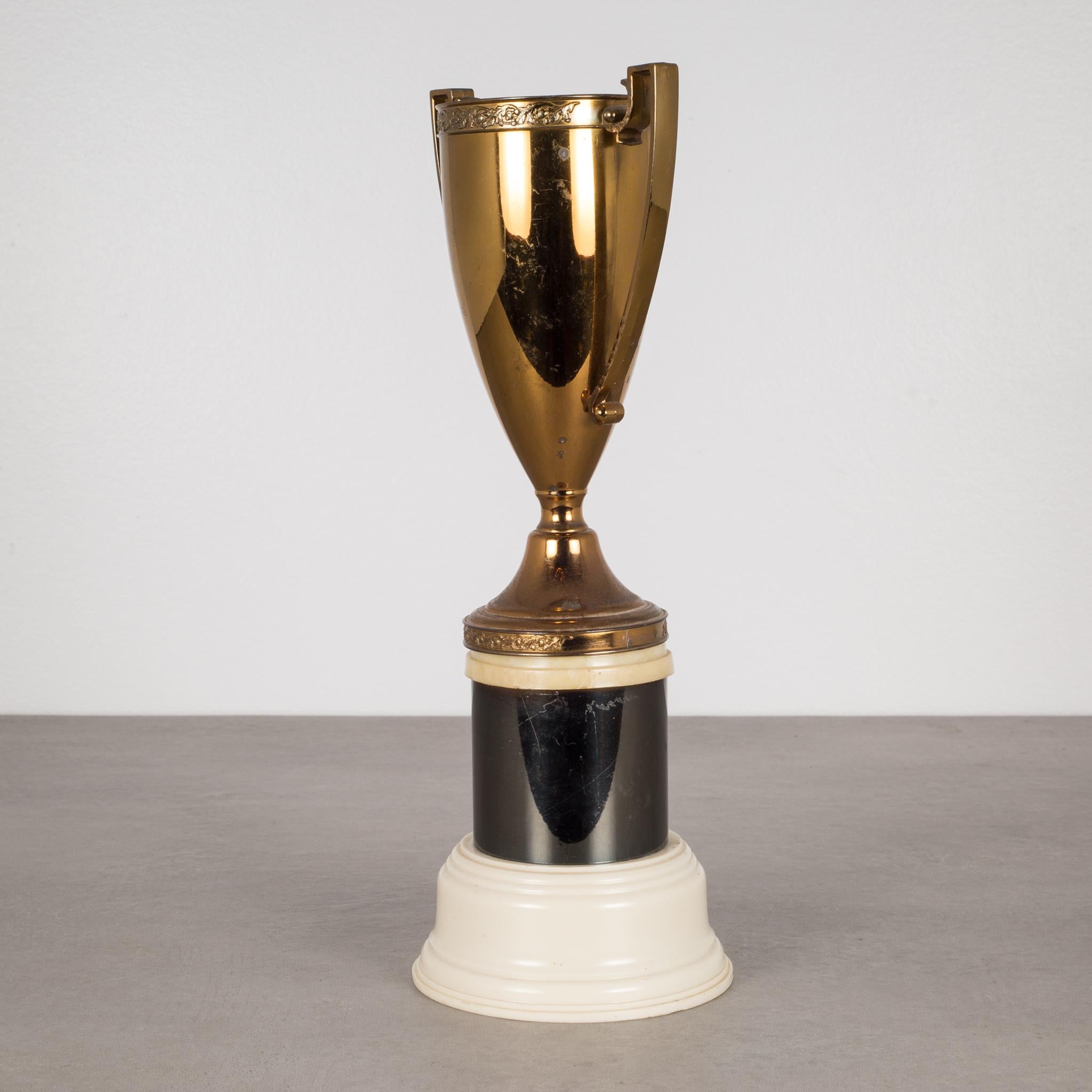 Solid brass loving cup on a black and off white Bakelite base manufactured by Dodge Inc.
No inscription on the body.