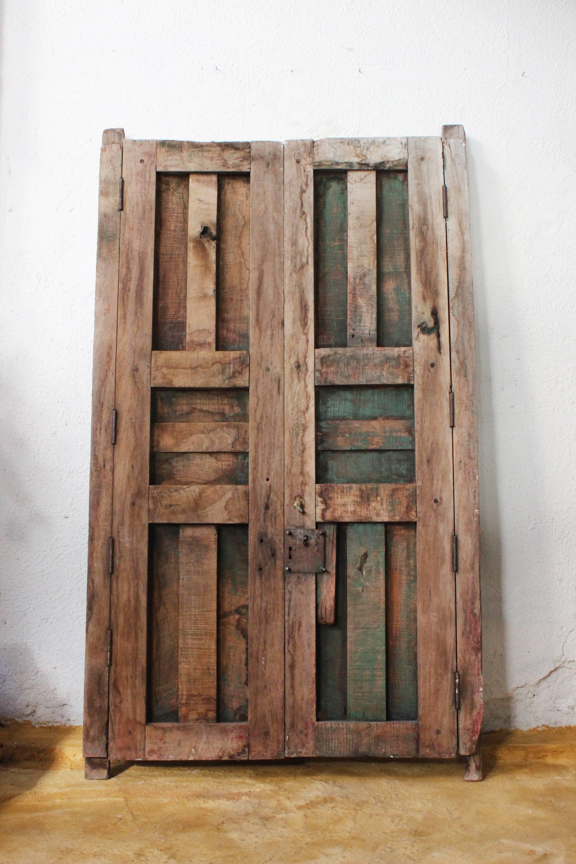 An early 20th century medium sized solid mesquite pair of doors found in Western México, the wood has fabulous cracking, great for many different applications such as a headboard, wall hanging, kitchen pot rack or just a backdrop layer in an