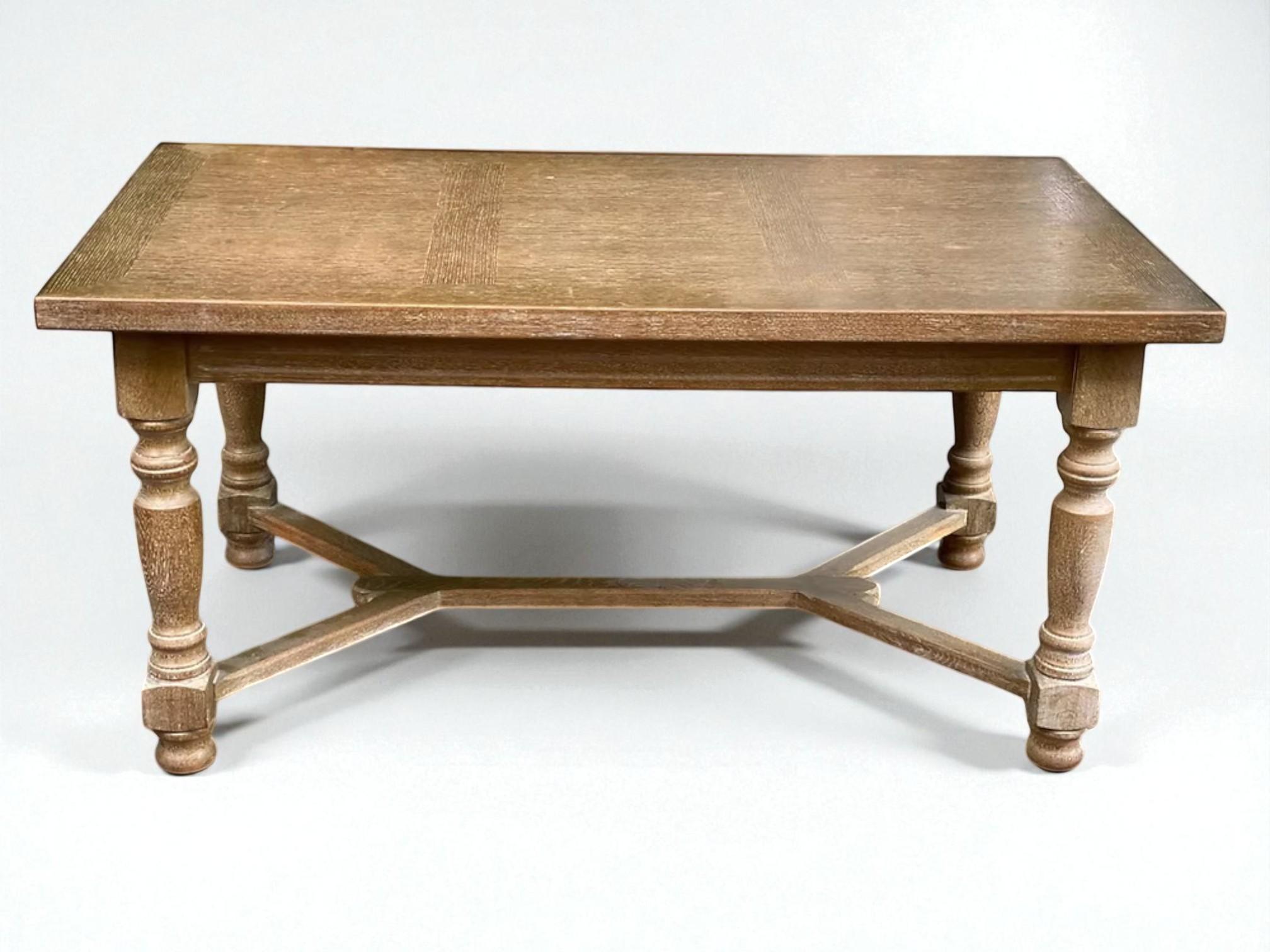 Questo robusto tavolo da pranzo riflette il fascino duraturo dell'artigianato tradizionale europeo, probabilmente proveniente dalla Francia o dal Belgio. Realizzato in rovere massiccio, presenta uno spesso piano rettangolare con sottili intarsi