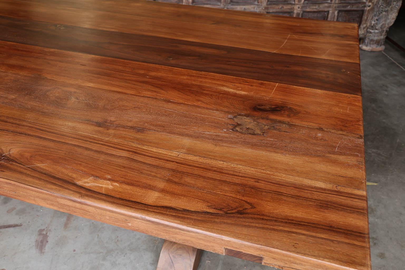 This is a quintessential example of the type of furniture made during the heydays of the British rule in Asia. Strong, durable, elegant and functional sparing no effort or material or cost. This is a thick top solid teak wood table supported on both